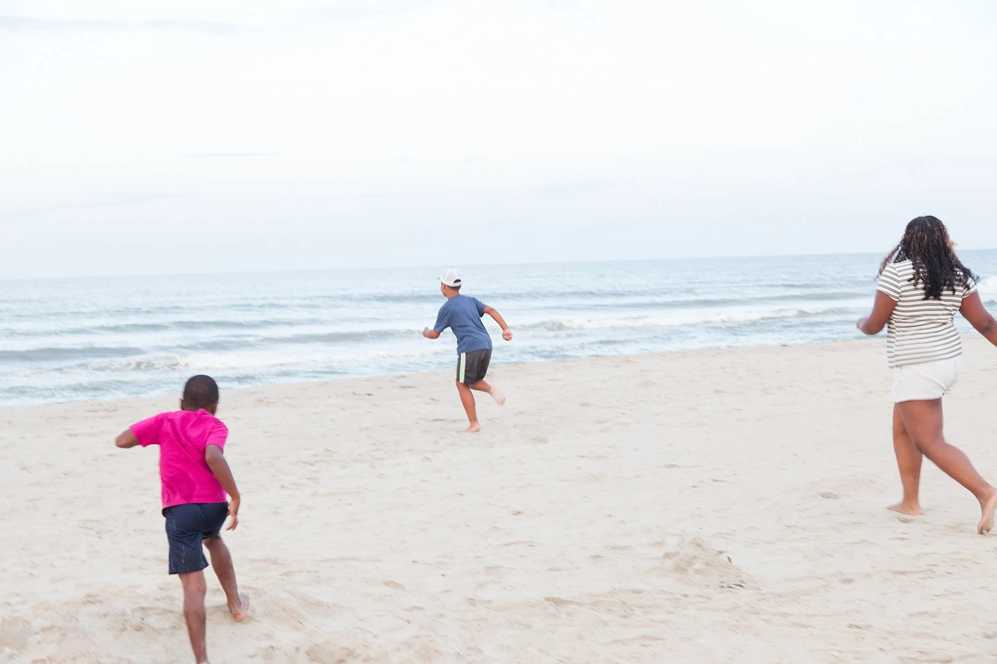 kids running together on beach in NC