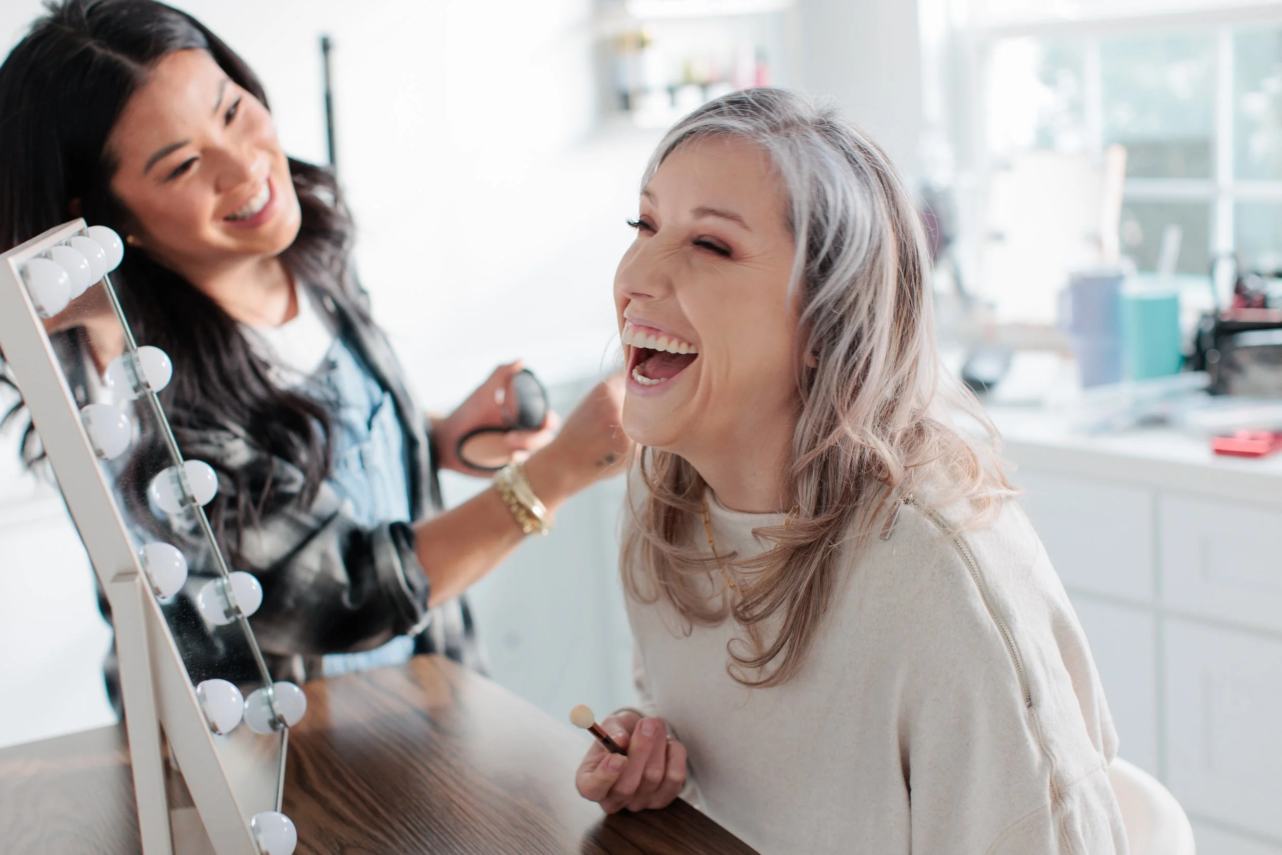 makeup artist and client laughing together