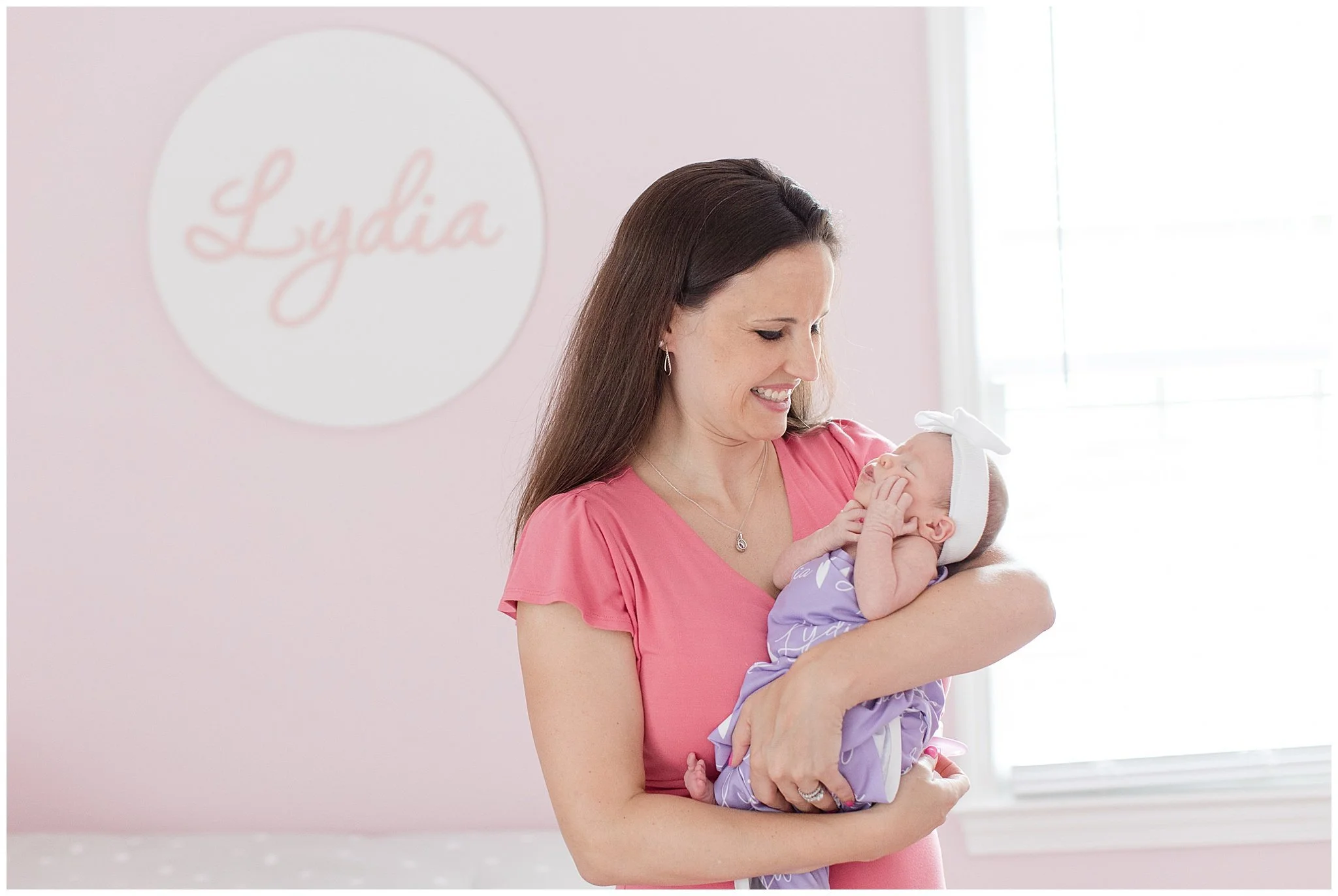 mom holding her newborn baby in nursery in bethesda md
