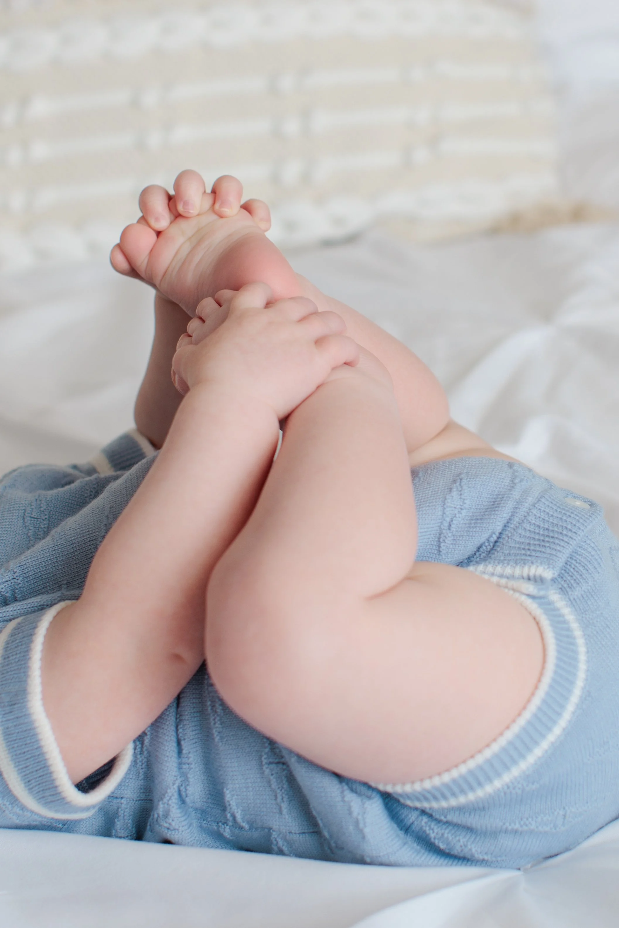 6 month old baby holding feet on bed in Silver Spring studio