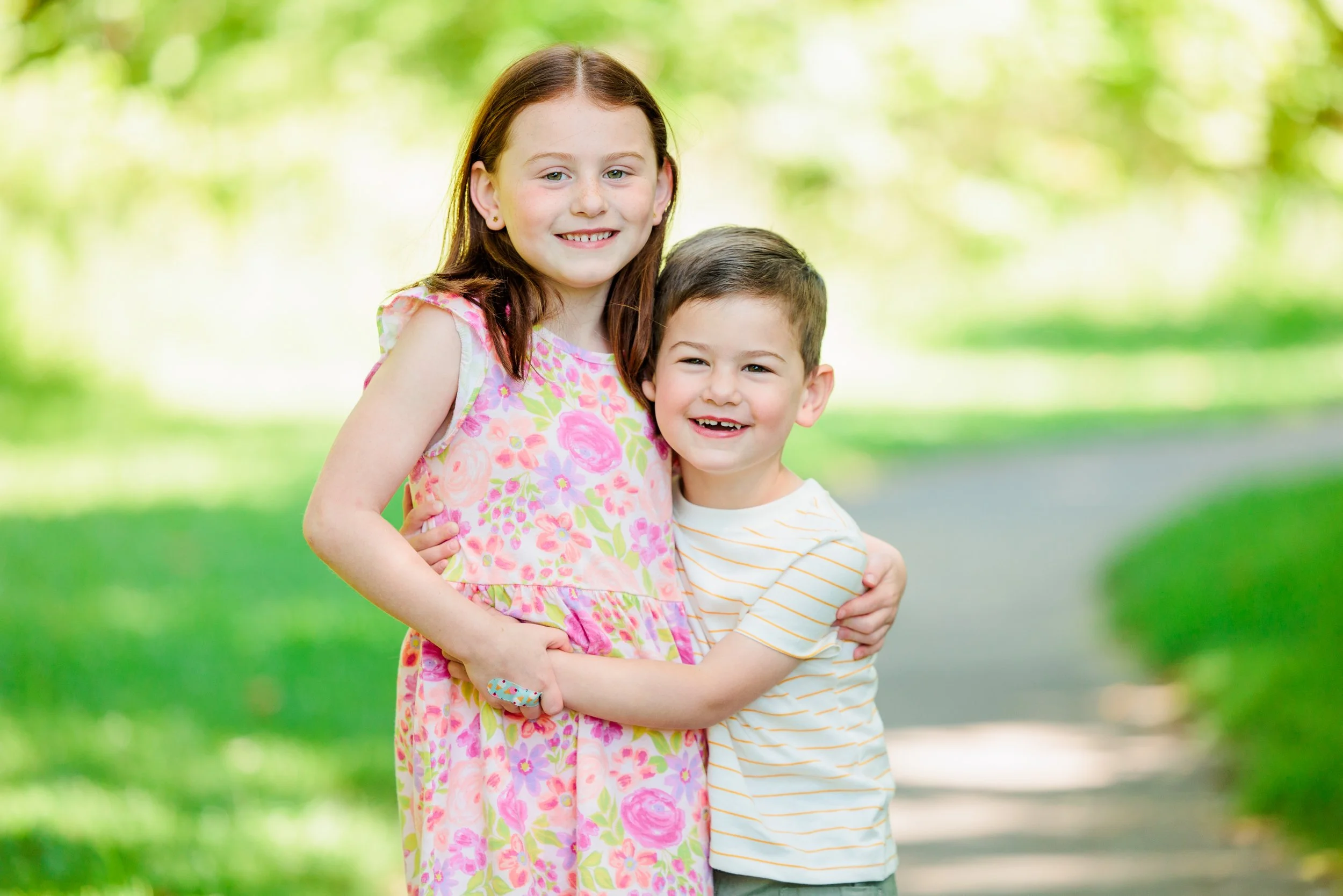 Siblings hugging during a playful spring family photo session in Maryland