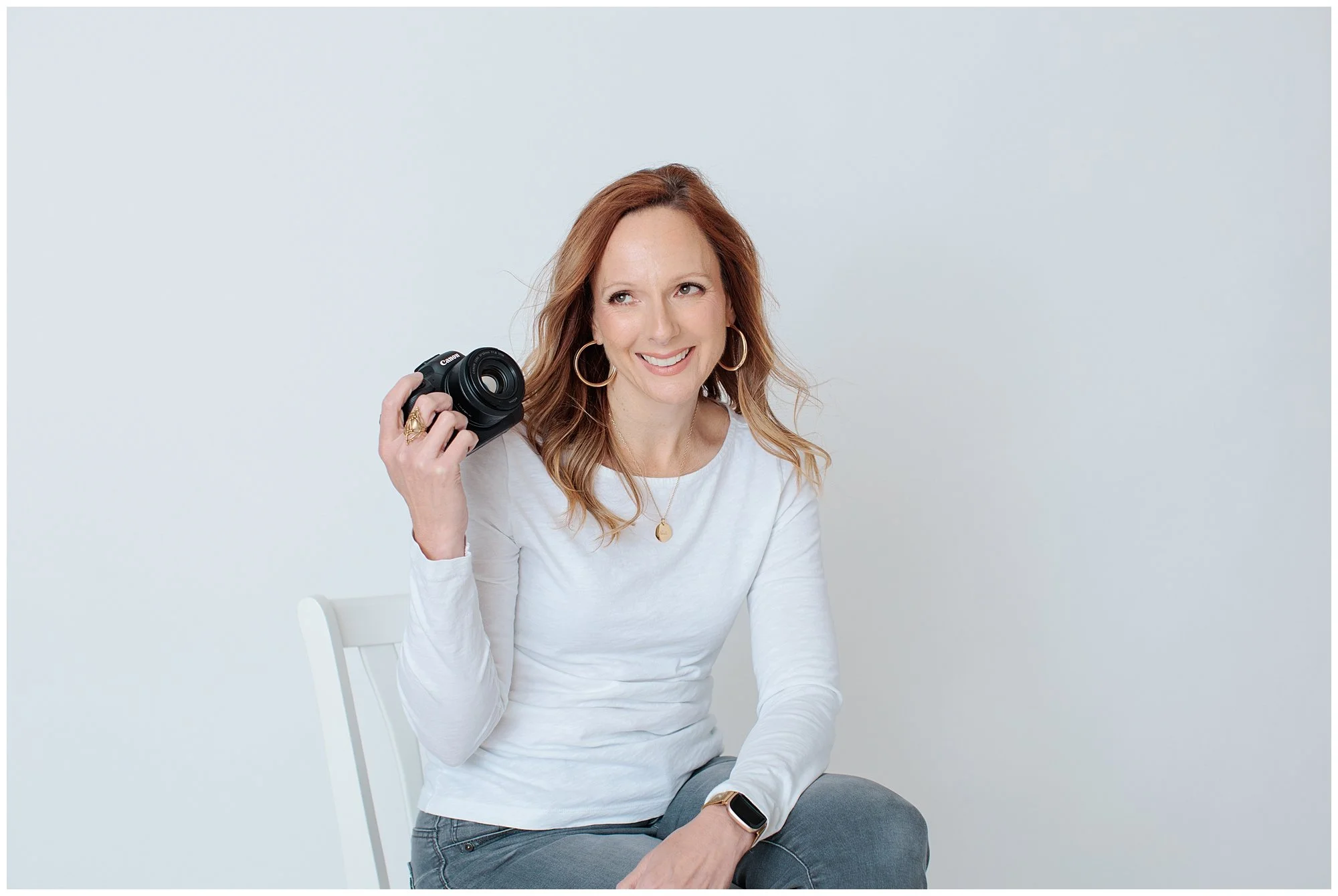 Photographer with camera against a white background in Silver spring Maryland studio