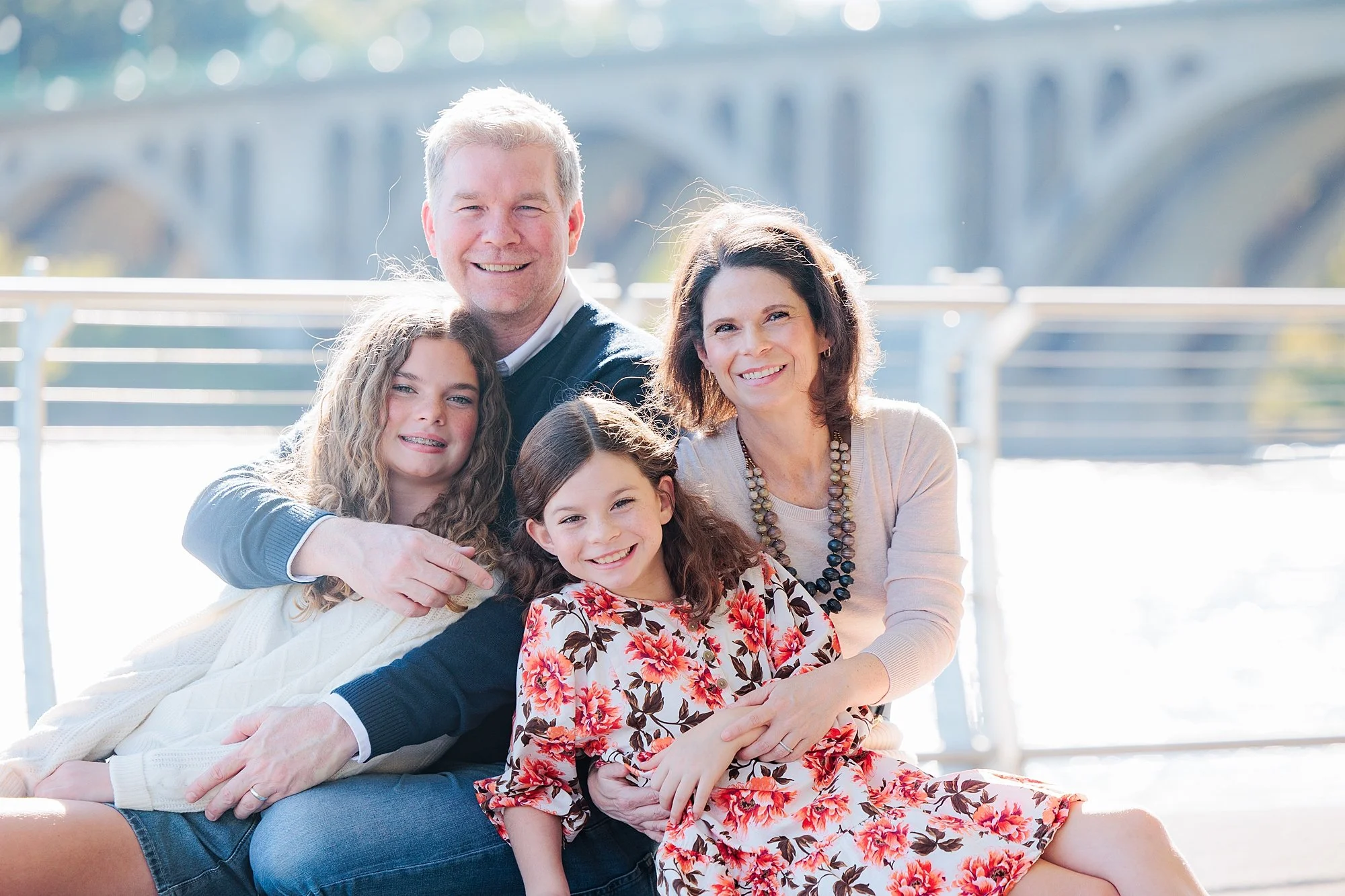 family sitting together at Georgetown waterfront for family photo session
