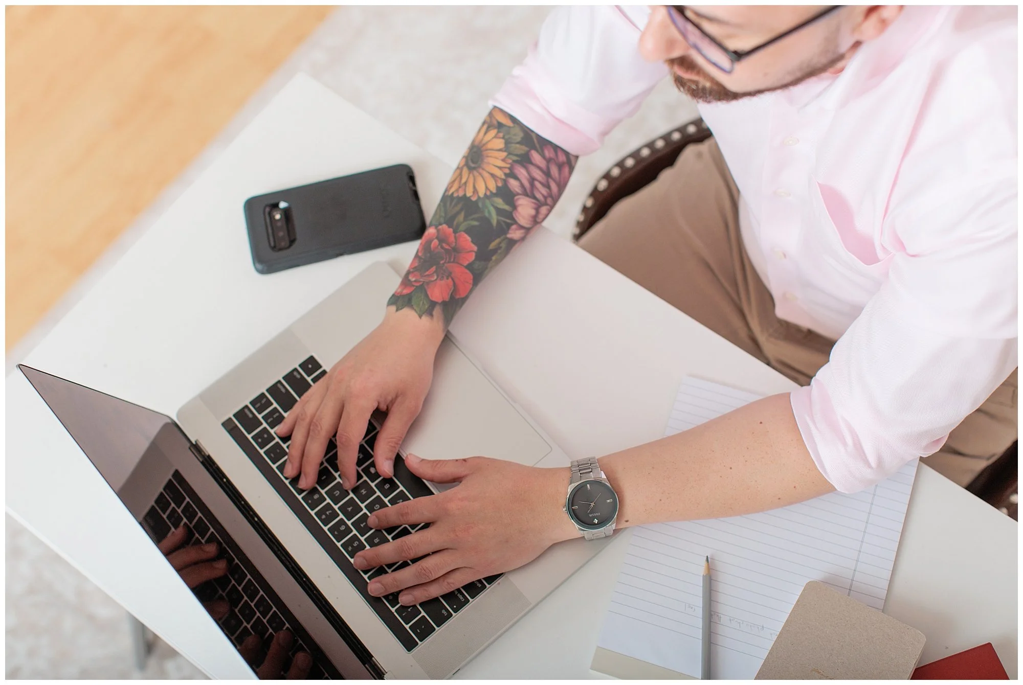 overhead shot of man with tattoo on laptop