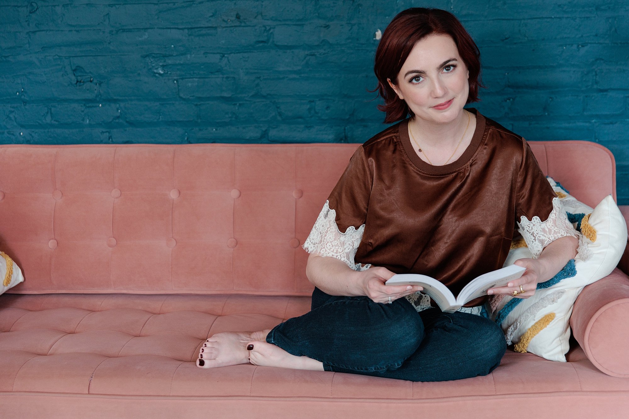 Personal branding portrait of Jen seated with books in a Baltimore interior