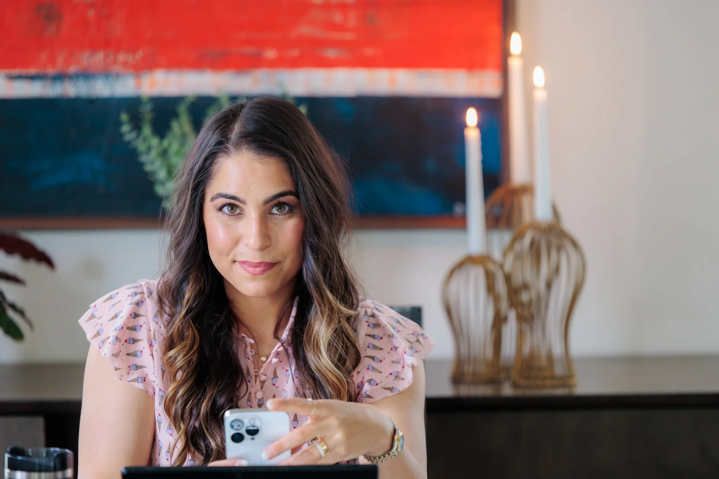 brand photo of female entrepreneur at desk looking at computer and phone