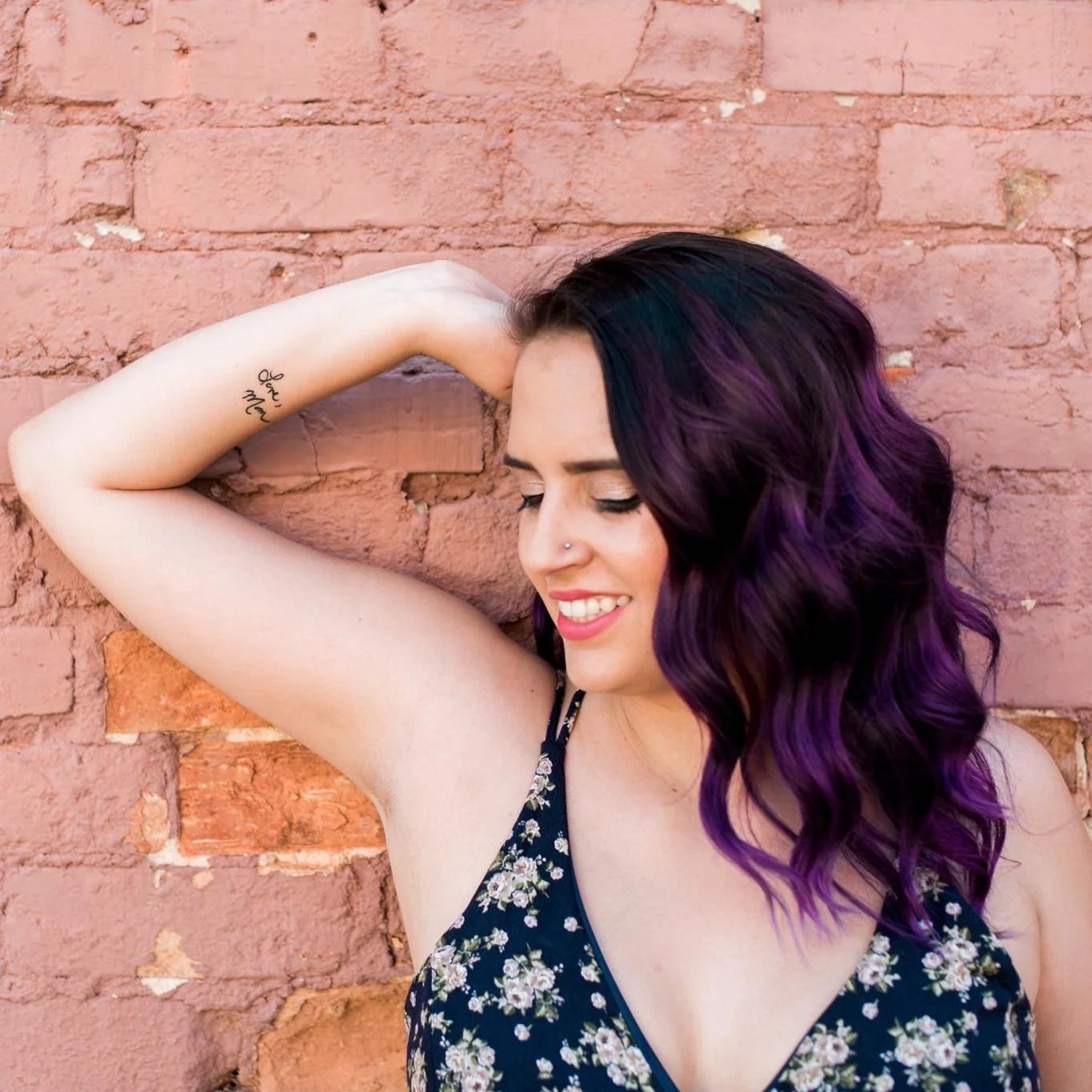 High school senior girl with purple hair against a brick wall