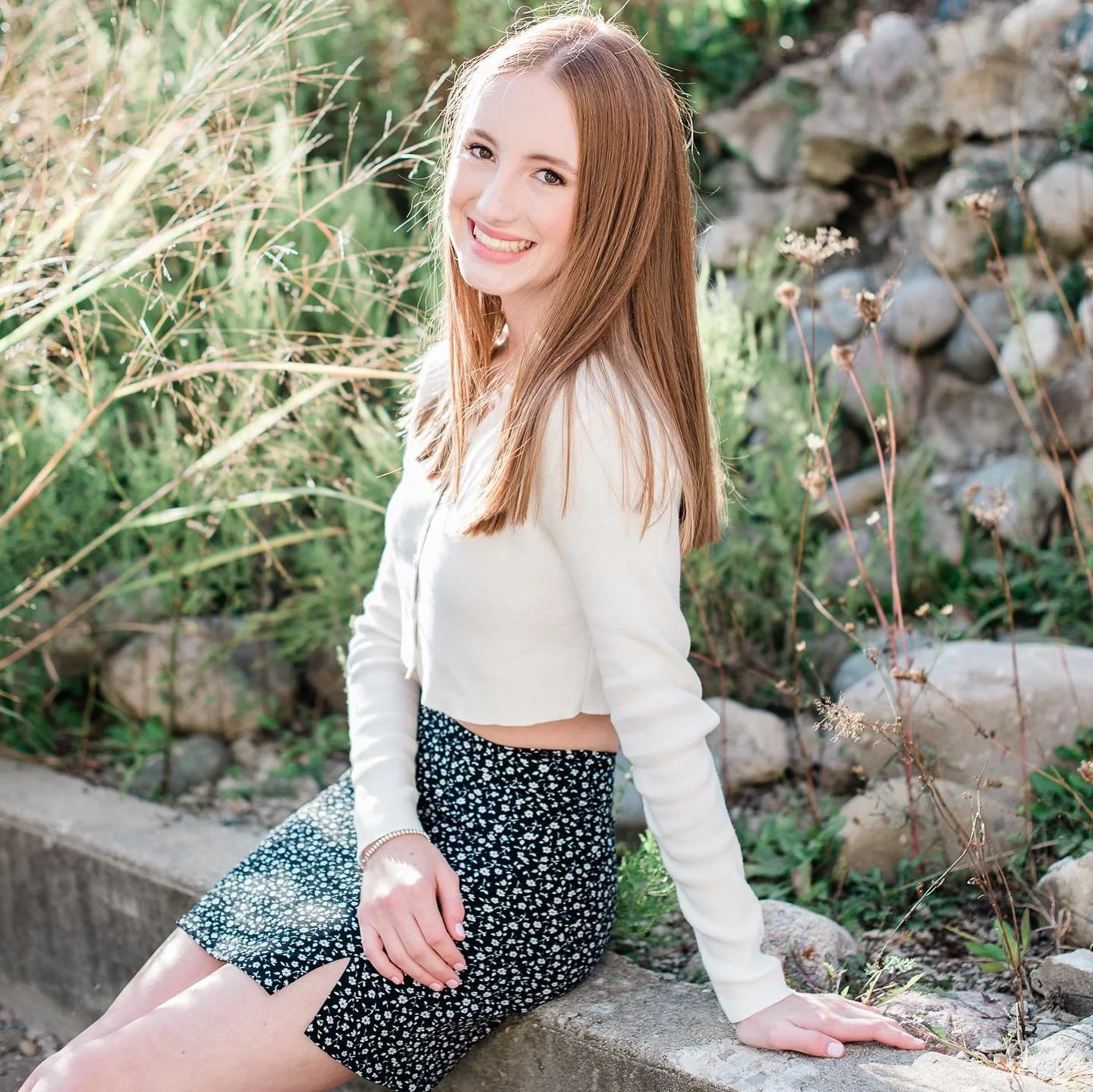 North Carolina Senior Photographer Girl sitting along a rock wall.