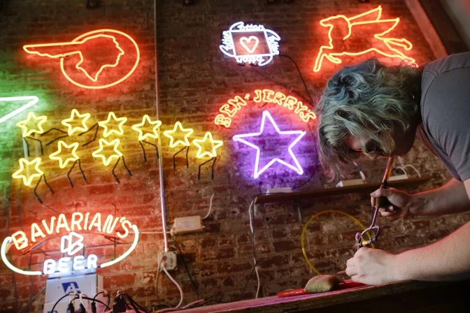 Martin Wartman, a student at Northern Kentucky University, works on a neon sign at the Neonworks of Cincinnati workshop connected to the American Sign Museum, in 2016. (John Minchillo / AP)