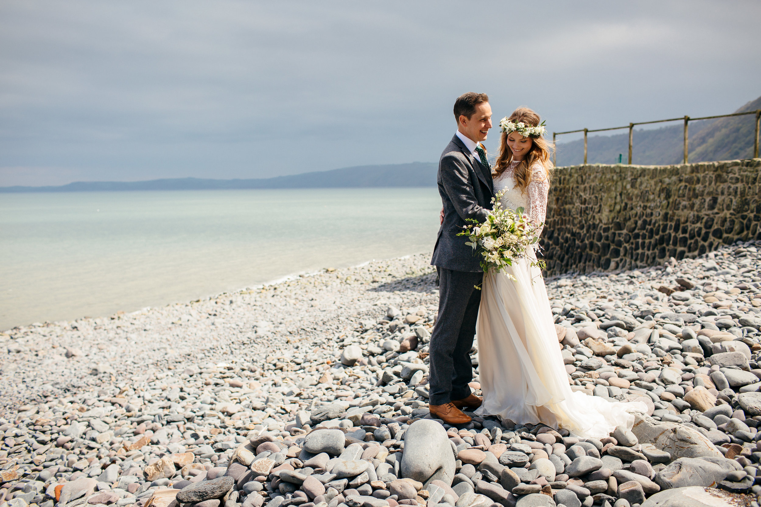 Bride and Groom on beach with flower crown and winter floral wedding bouquet