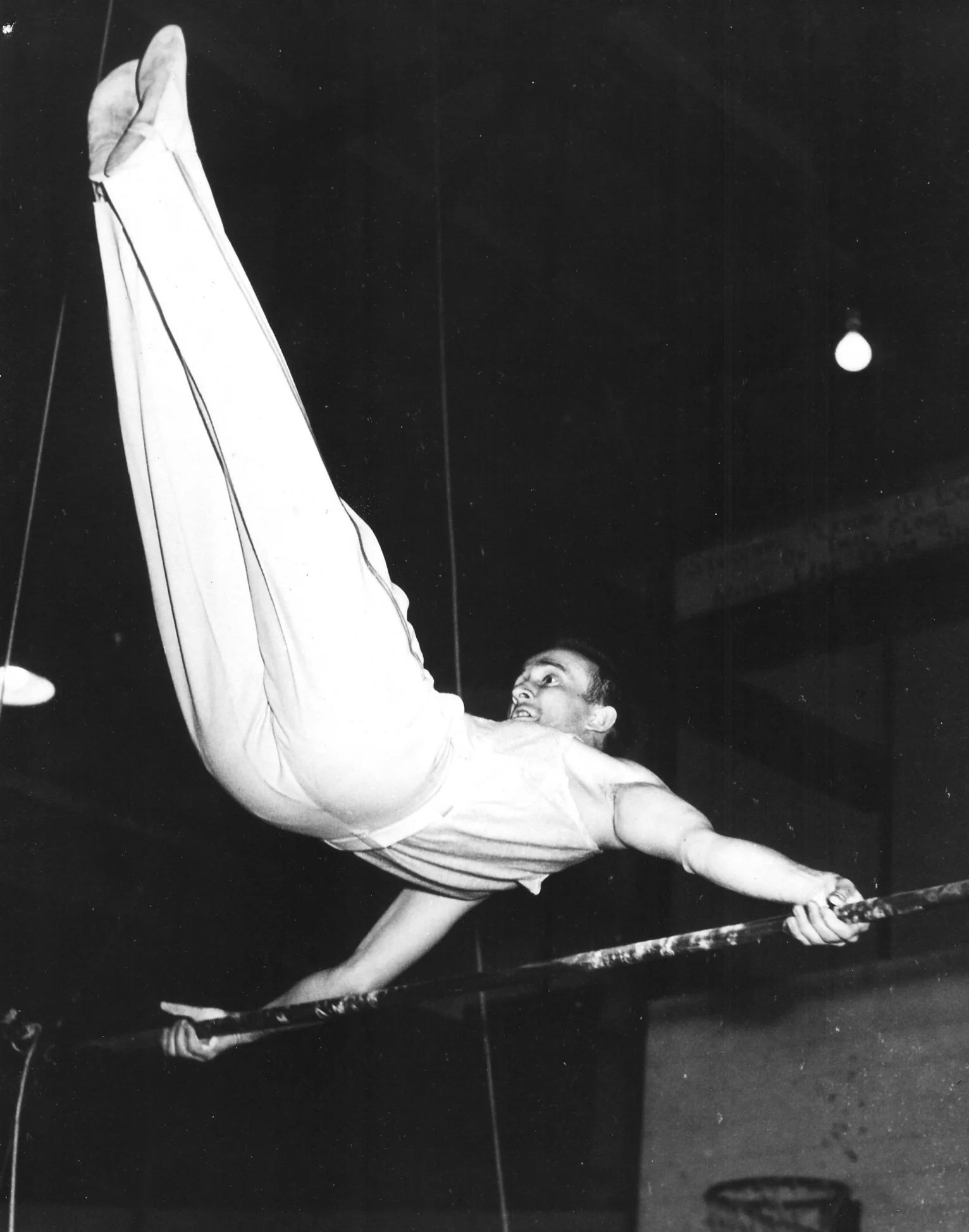 Capt. Charles Pinckney doing an Eagle on the Horizontal Bar (1950)