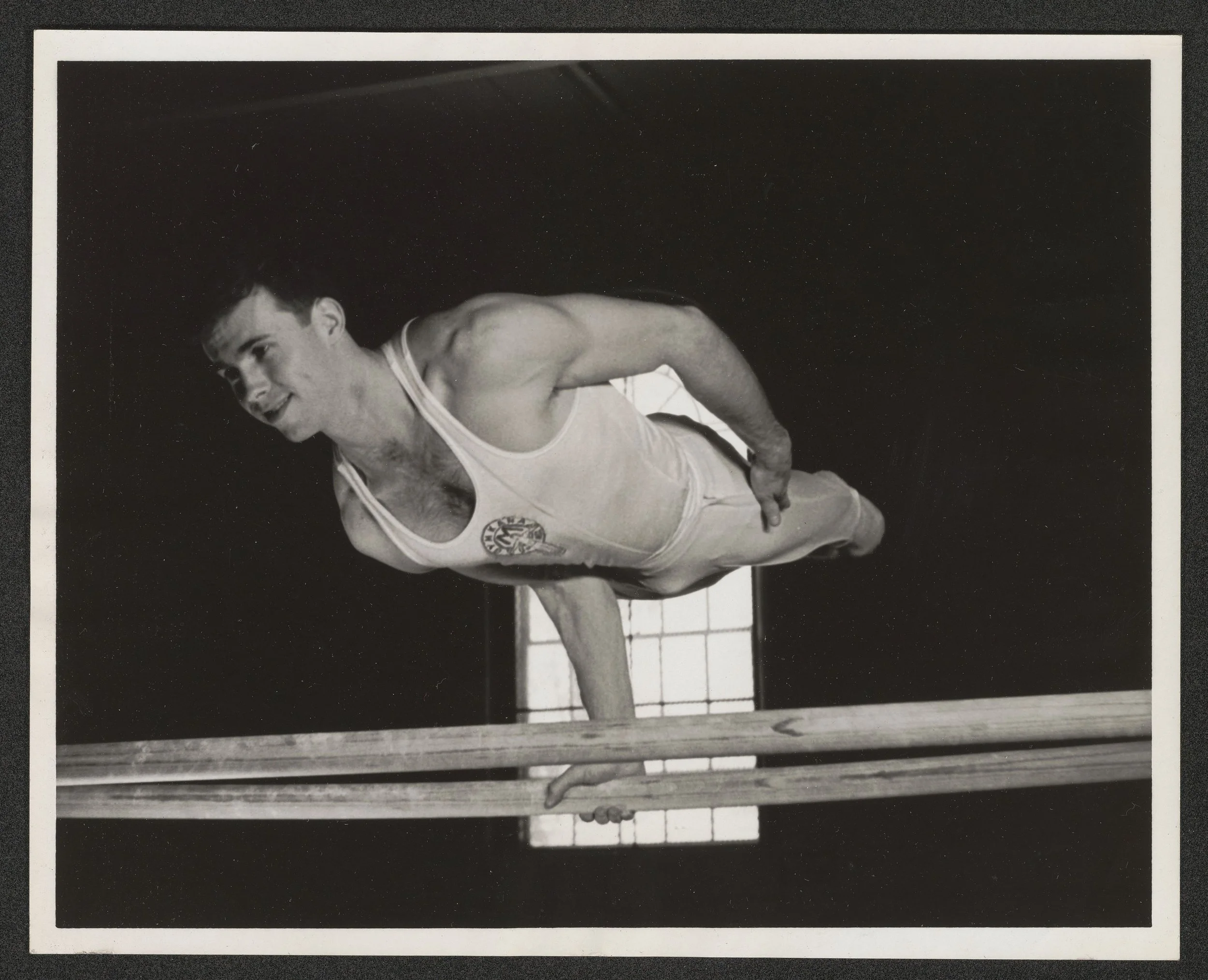  Joe Murray performs single arm elbow lever on parallel bars 