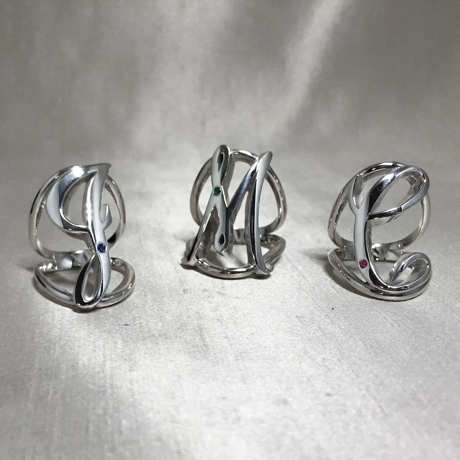 Custom Initial Rings with Birthstone Gems.