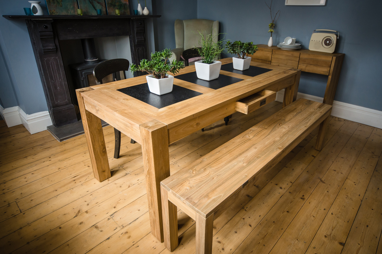 Our one-of-a-kind LAVA dining tables have plates of smooth volcanic lava inlaid in their tops. Glossy black lava provides a heatproof, durable surface as well as a striking colour contrast against our honey coloured reclaimed teak.