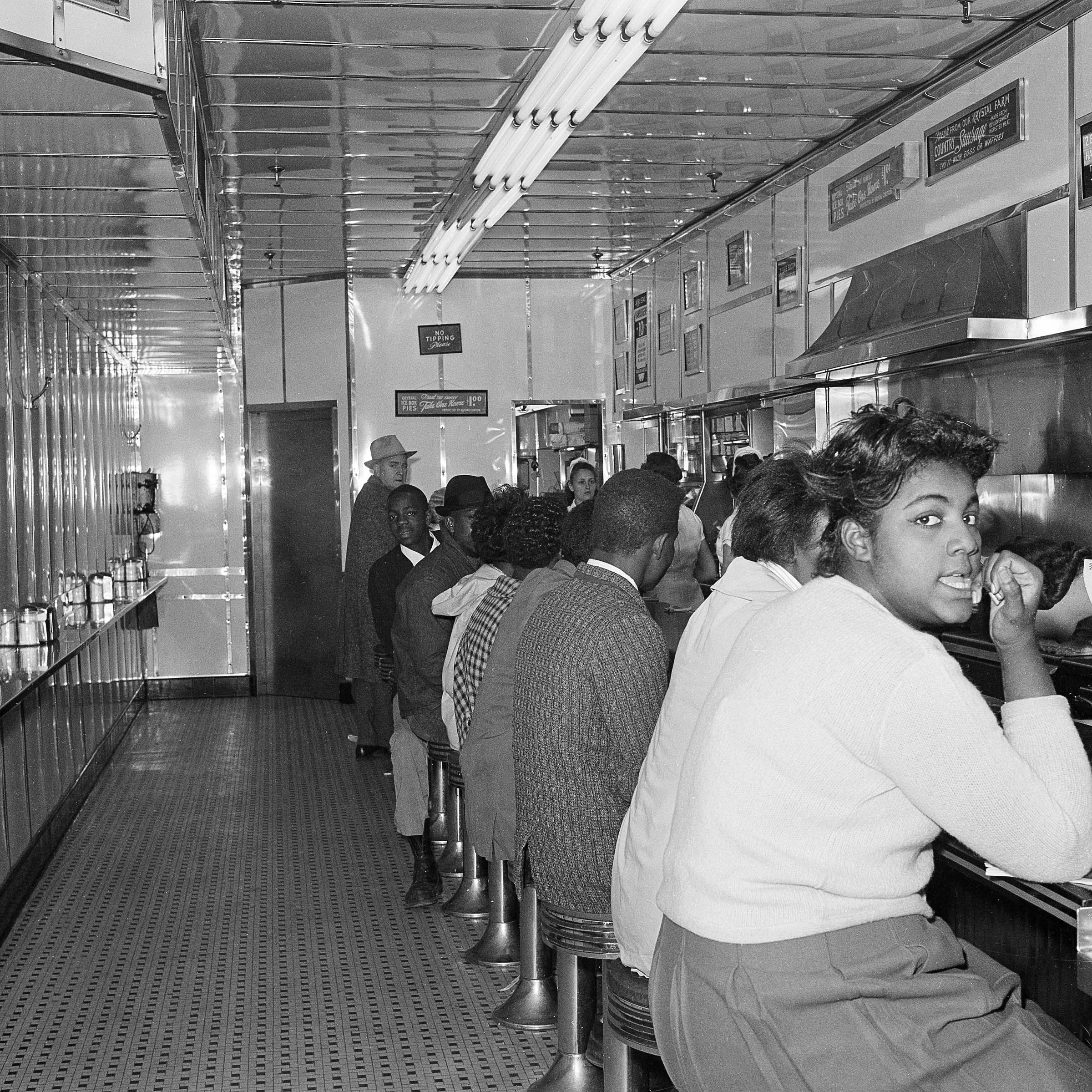 PAGE 61: IN EXAMINING AFRICAN-AMERICANS' QUEST FOR FREEDOM, NONVIOLENT DIRECT-ACTION TACTICS VARIED BASED ON, IN THE WORDS OF CONGRESSMAN JOHN LEWIS, "DIFFERENT FORMS OF OPPRESSION." PICTURED HERE, ATLANTA UNIVERSITY CENTER STUDENTS STAGE A SIT-IN AT A DOWNTOWN ATLANTA LUNCH COUNTER IN JANUARY 1964 (PERMISSION OF THE ASSOCIATED PRESS). 