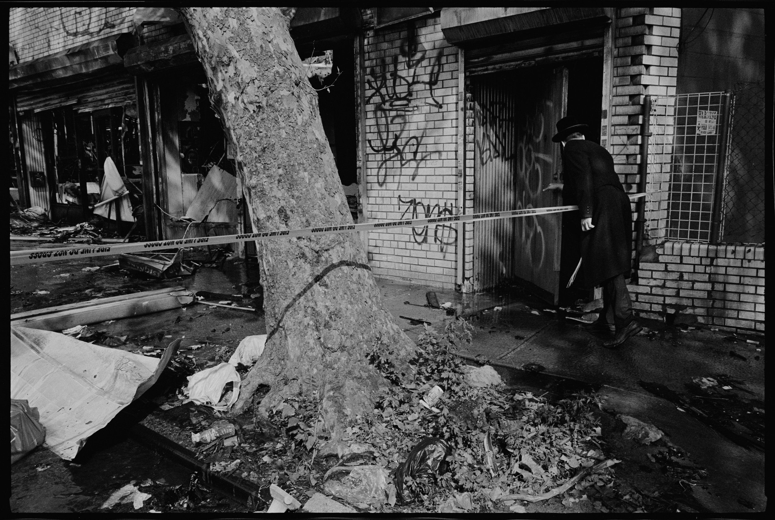 Man peering into burned building, Williamsburg St E