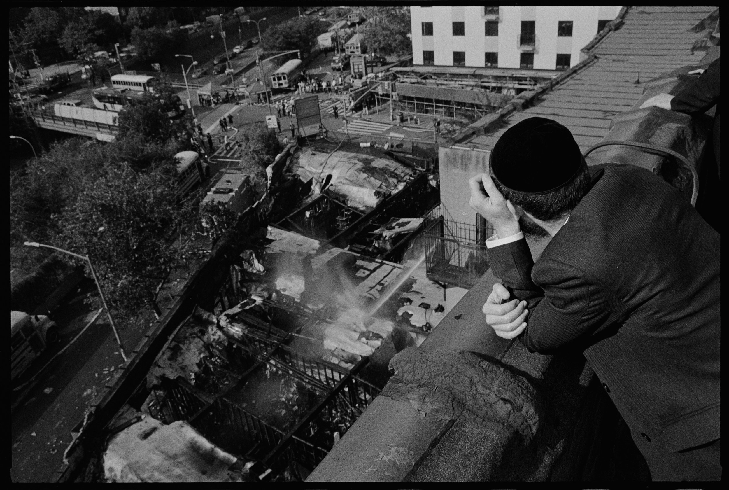 Man looking down at burned rooftops, Hooper St