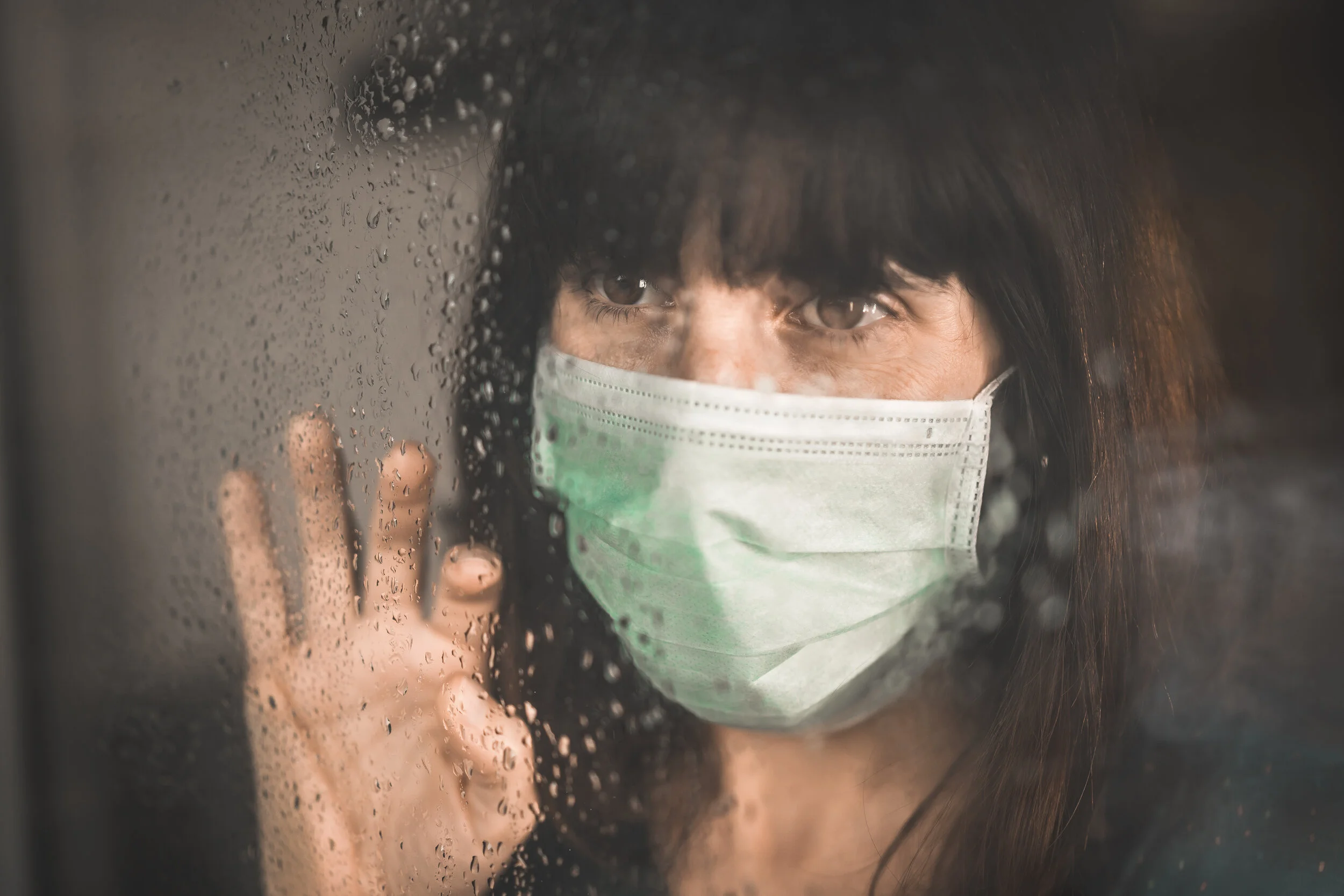 young-woman-wearing-mask-covid-19-pandemic-with-her-hand-window-looking-through.jpg