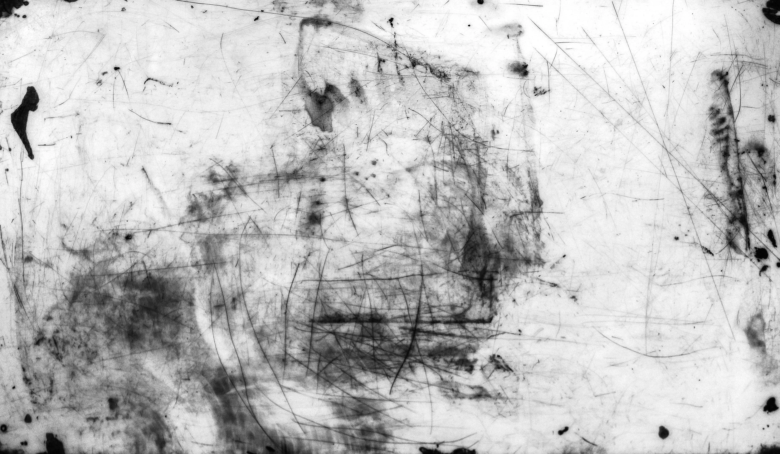 Black and white abstract image with various lines, smudges, and irregular shapes.