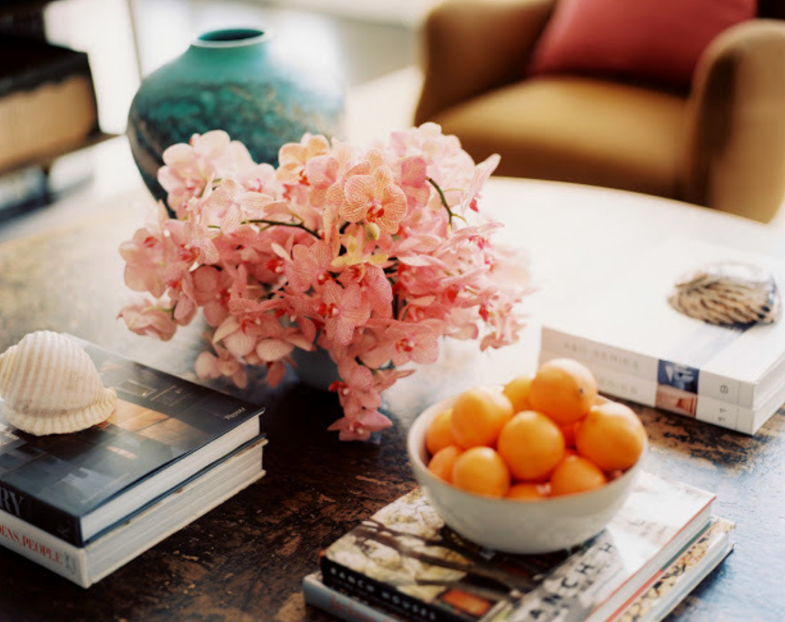 We are always looking at interior design resources for new ideas and color combination. Here an arrangement of delicate pink orchids work so nicely with the teal vase and bowl of orange clementines. Pulled from our Pinterest page.