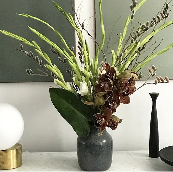 Focal point arrangements are often a mix of long lasting flowers. Here we have cymbidium orchids, gladiolus, and pussy willow.