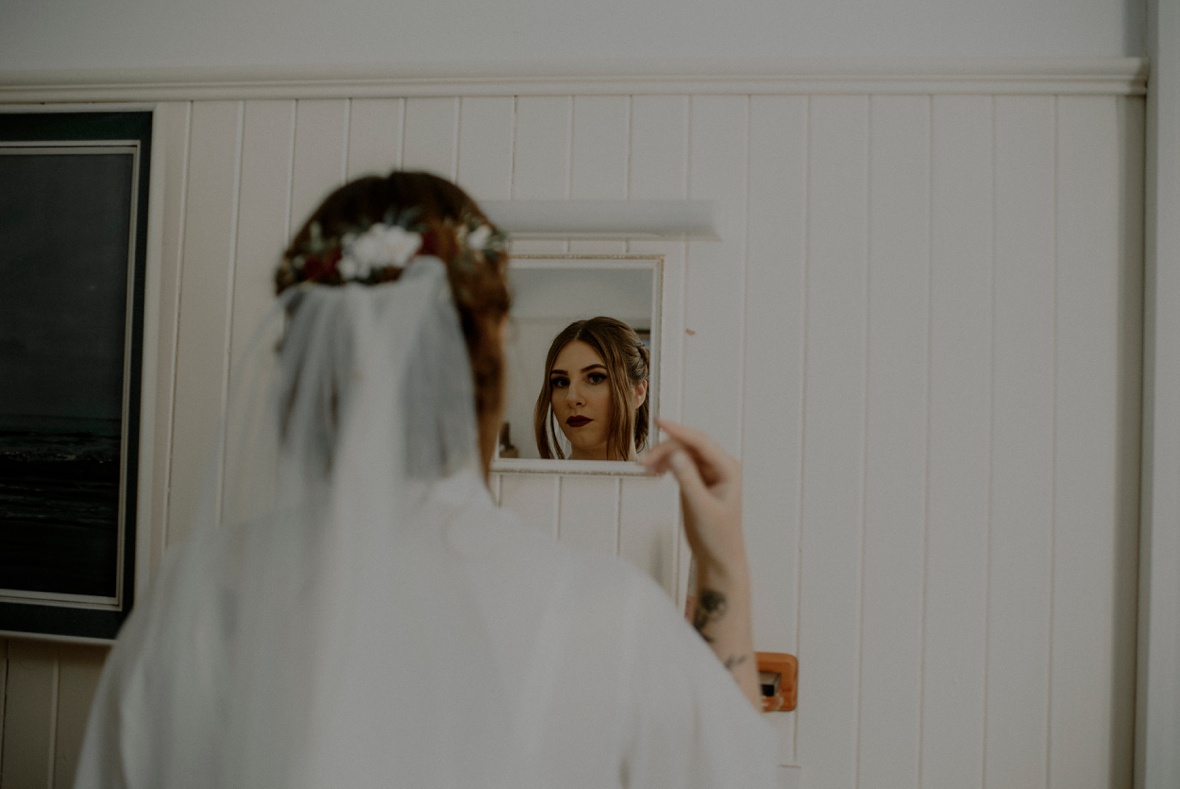 bride is checking hair in mirror