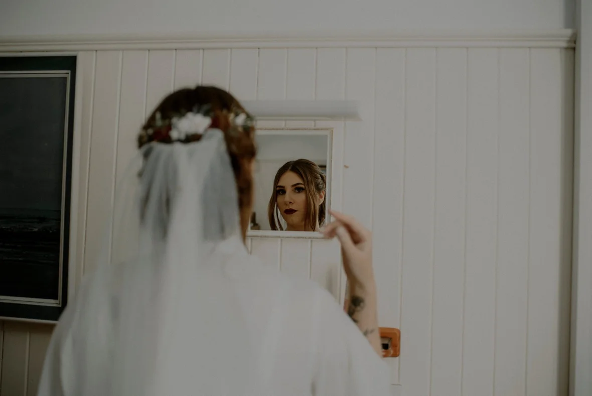 bride is checking hair in mirror