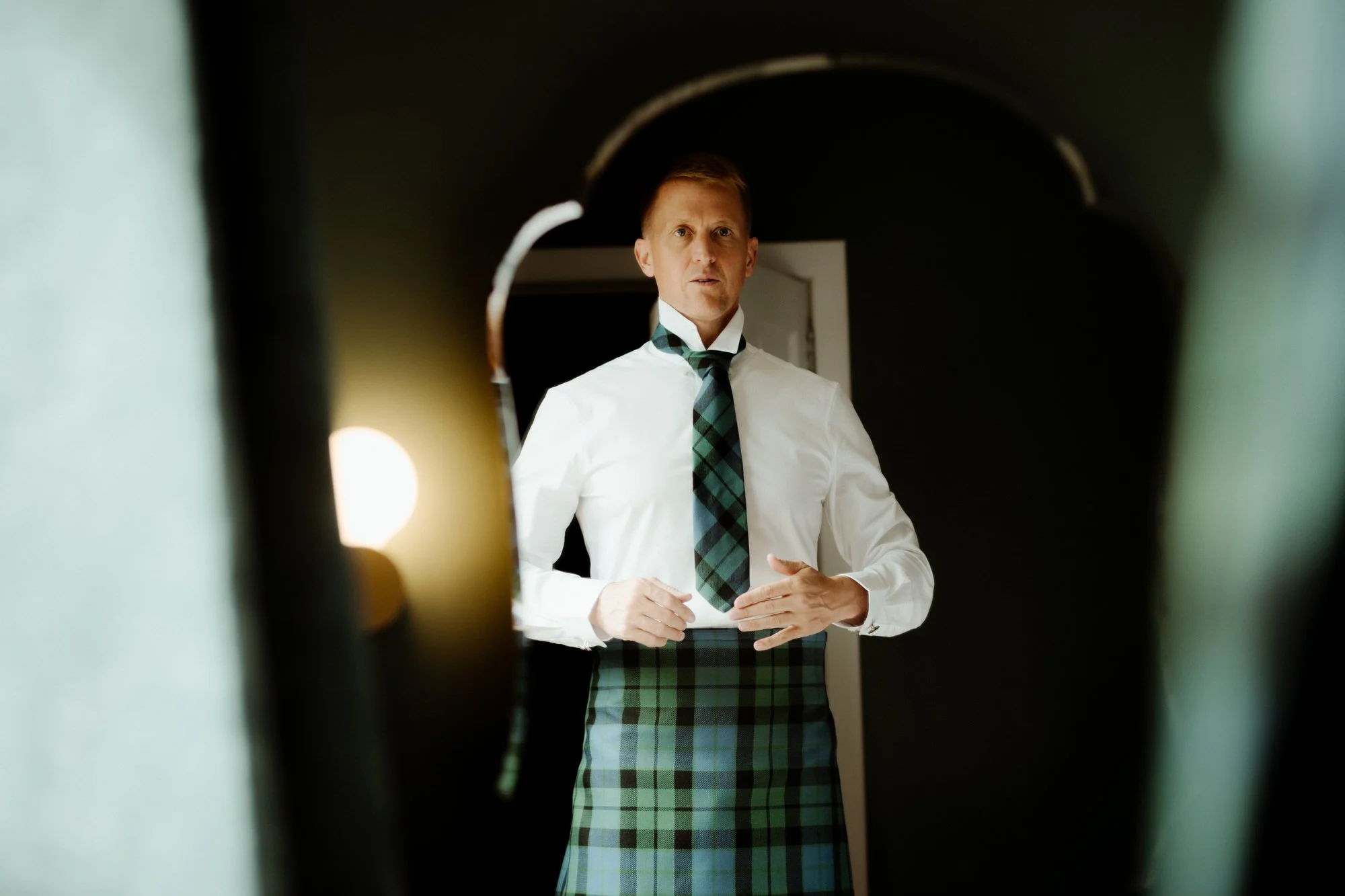 groom is getting ready in front of mirror