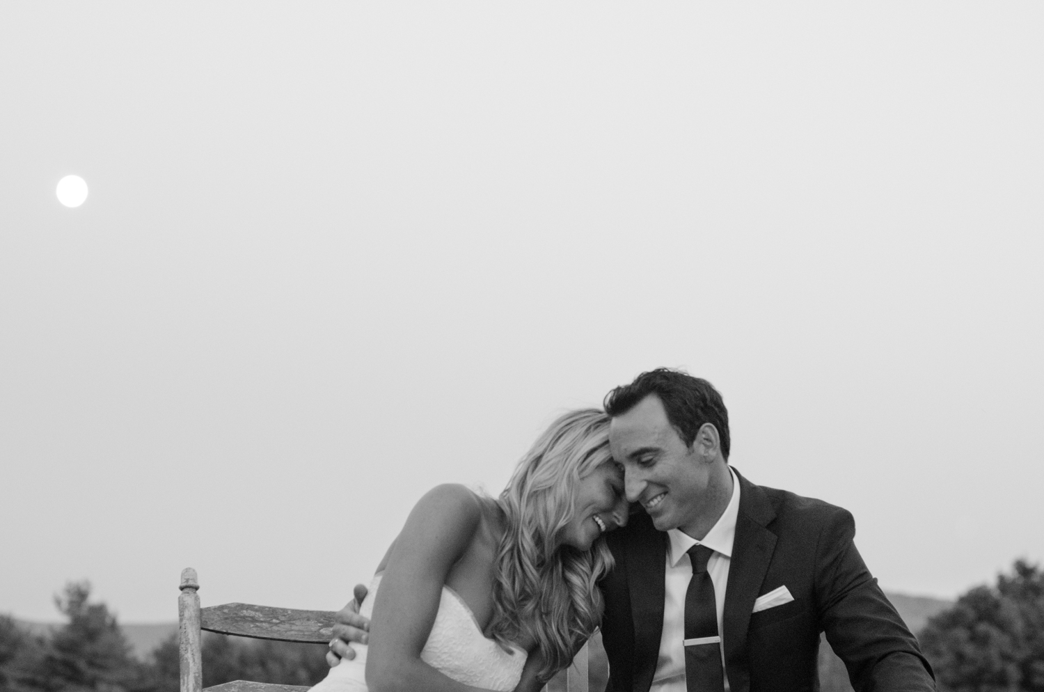 A playful bride and groom laughing at their mountain wedding.