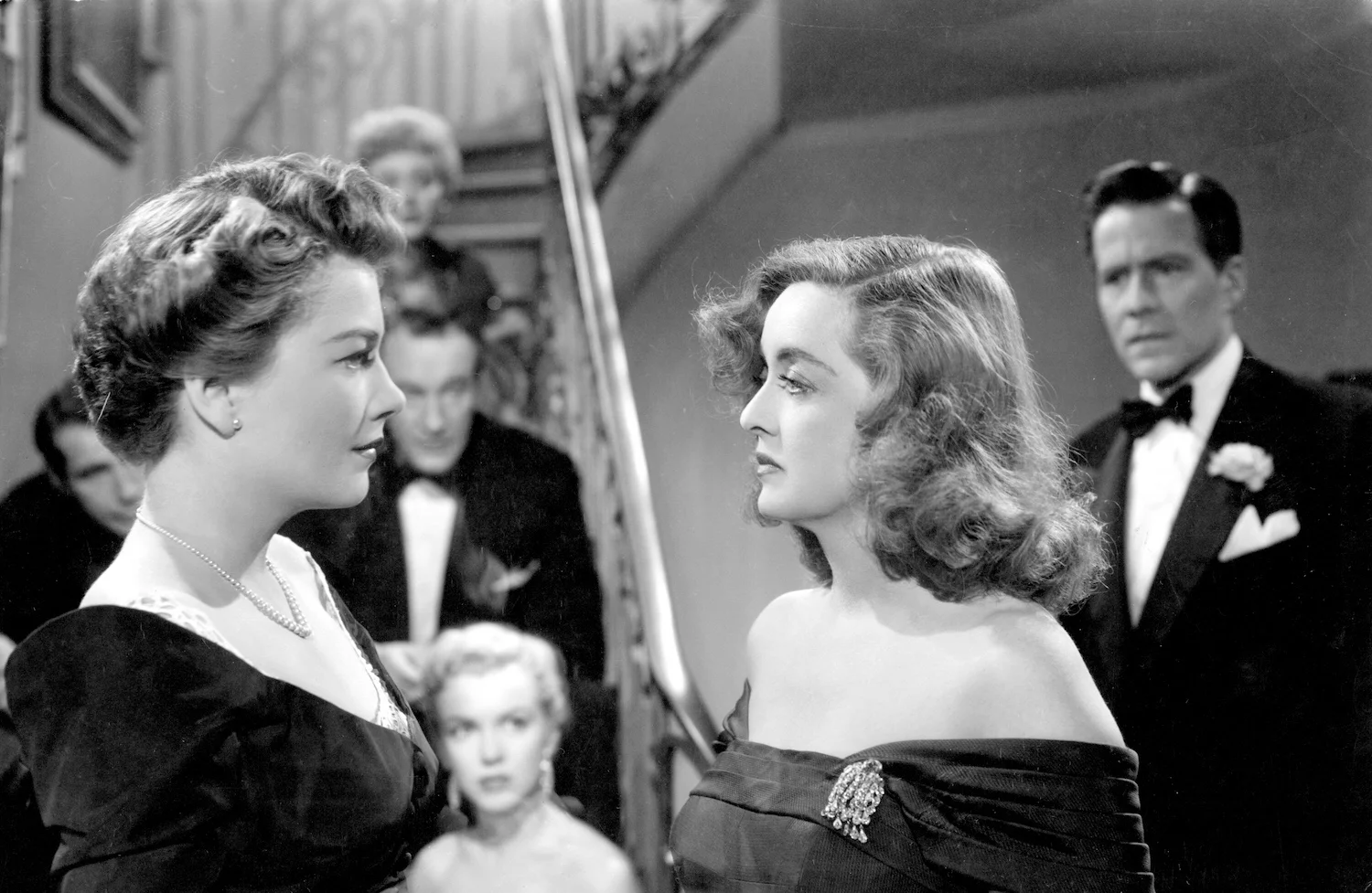 Anne Baxter (left foreground) and Bette Davis (right foreground) in All About Eve , with Celeste Holm (center top), George Sanders (center middle), and Marilyn Monroe (center bottom) looking on