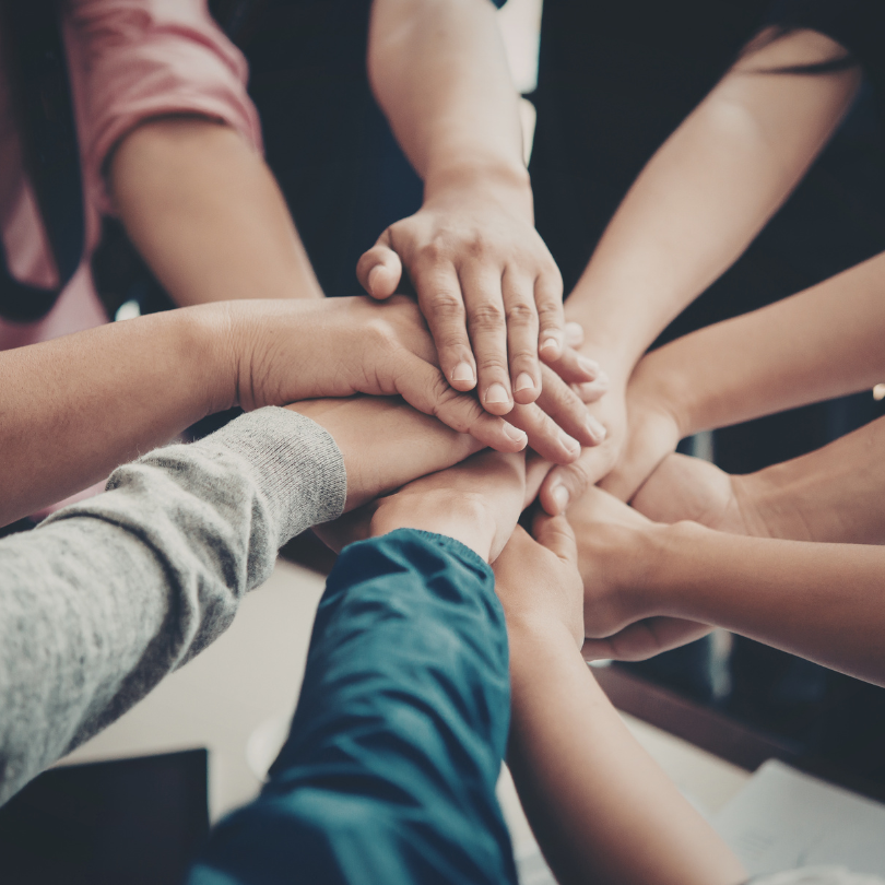 People standing in a circle stacking their hands