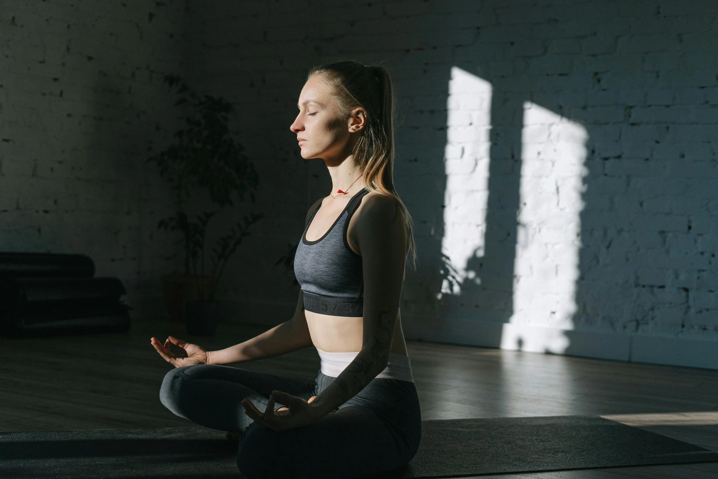 Woman meditating in a sunlit room finding stillness and calm