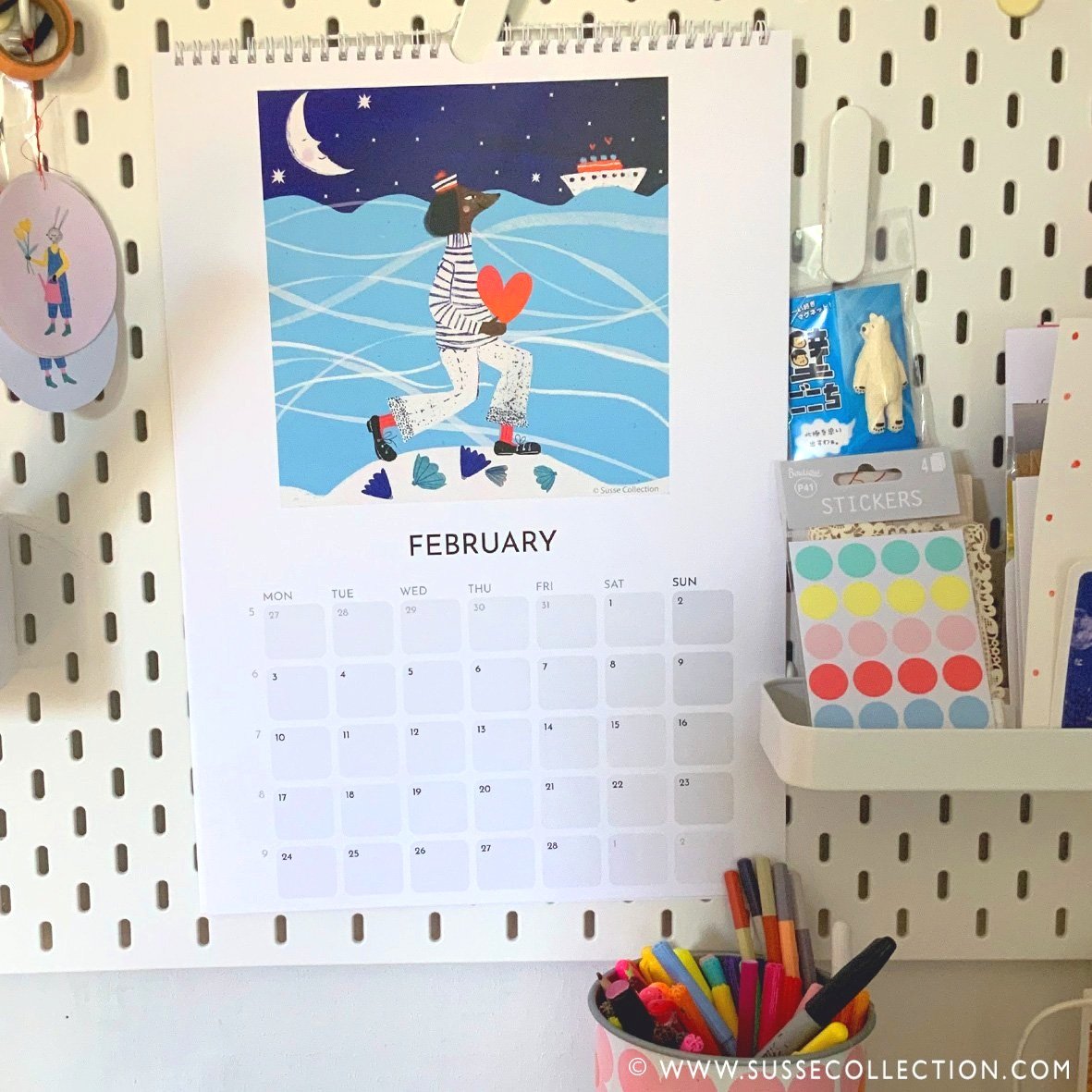 A photograph of the Susse Collection A3 Wall calendar illustrated By Susse Linton