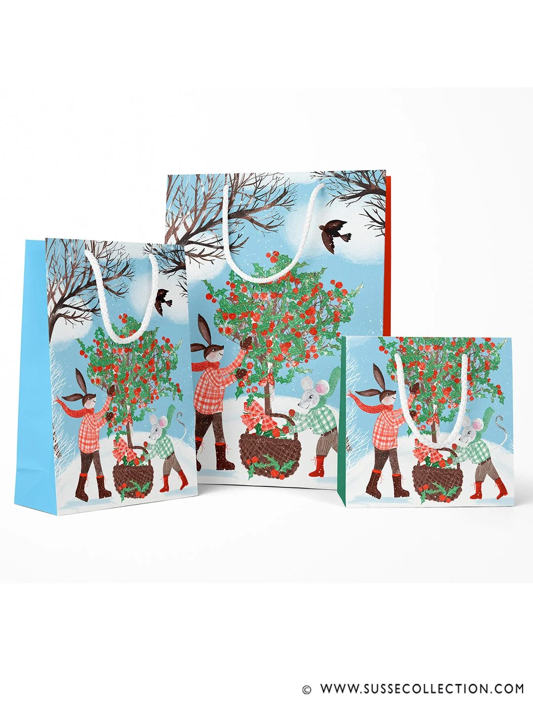 A photograph of an illustration fo a rabbit and mouse gathering holly in a winter snow scene.