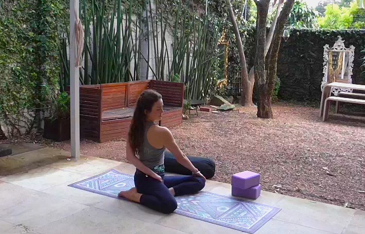 Sage twist. Place your hand on a block behind your back if you can't reach it around to grab the opposite inner thigh. Gently resist hips evenly into mat. Hold for 5 breaths on each side - flip your legs around to face the opposite side when you change over.