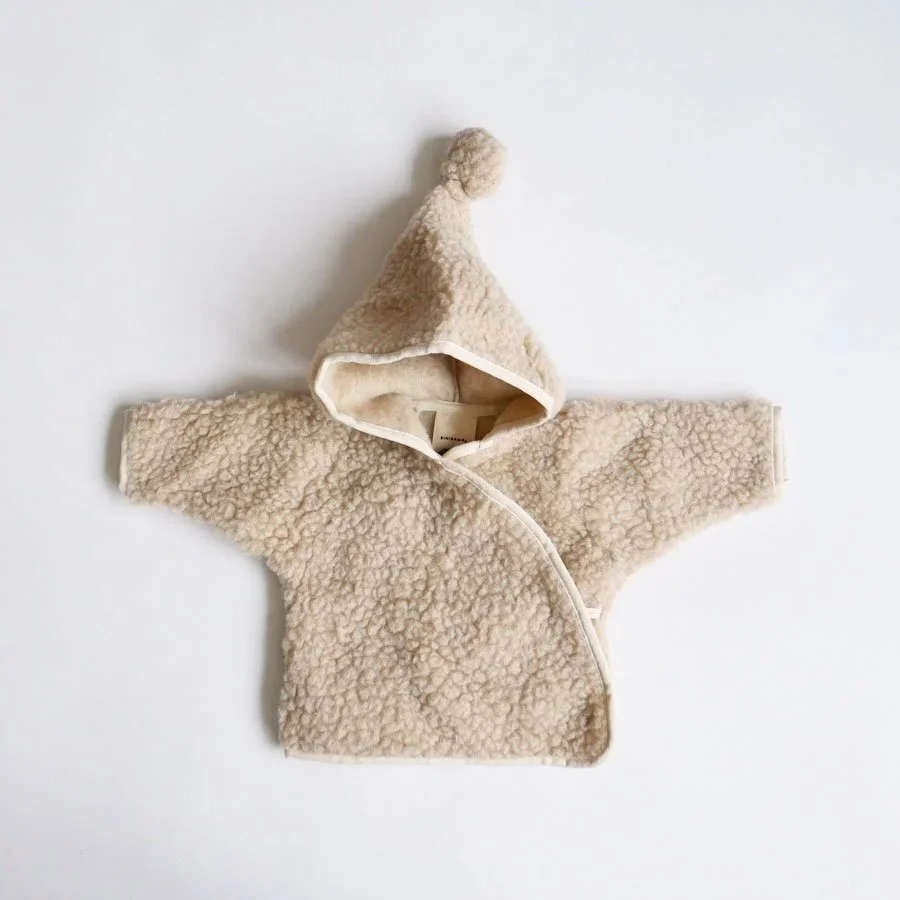 Meet the bestselling merino wool Snugglejacket! Perfect for those in-between days, this snuggly jacket features the signature pure teddy wool, wooden button fastening and pom pom hood. Binibamba&rsquo;s pure merino wool&rsquo;s temperature-regulating