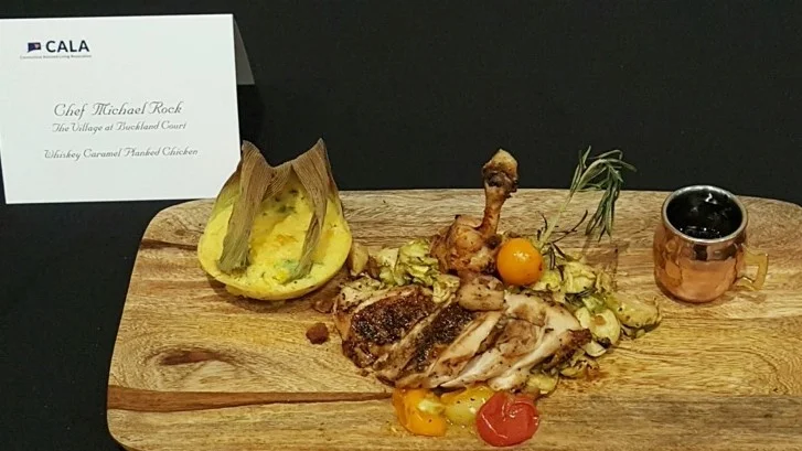 Chef Micheal Rock showcased his masterful skill with his winning chicken dish: Whiskey Caramel Planked Chicken, Jalapeno-Corn Pudding, Shaved Brussels and Pork Belly Slaw.