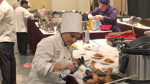 Corina uses a culinary torch to brown the marrow bone of the veal shank .