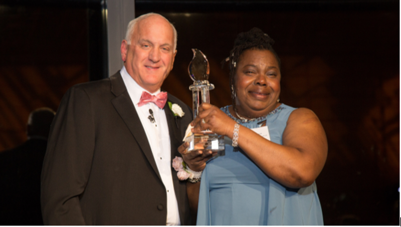 Norrett Burnett accepts the Compassionate Caregiver Award from Tom. Norrett is a Harbor Care Associate at Middlebrook Farms at Trumbull .
