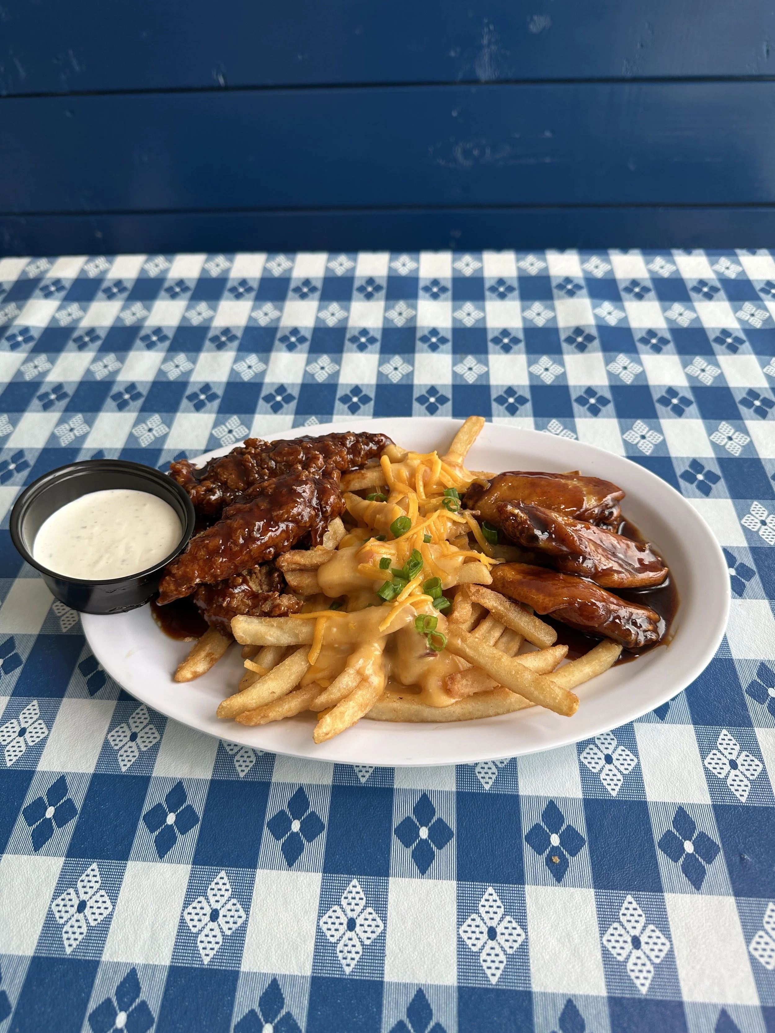 Bourbon-glazed chicken tenders and wings over cheese fries with scallions and a cup of ranch
