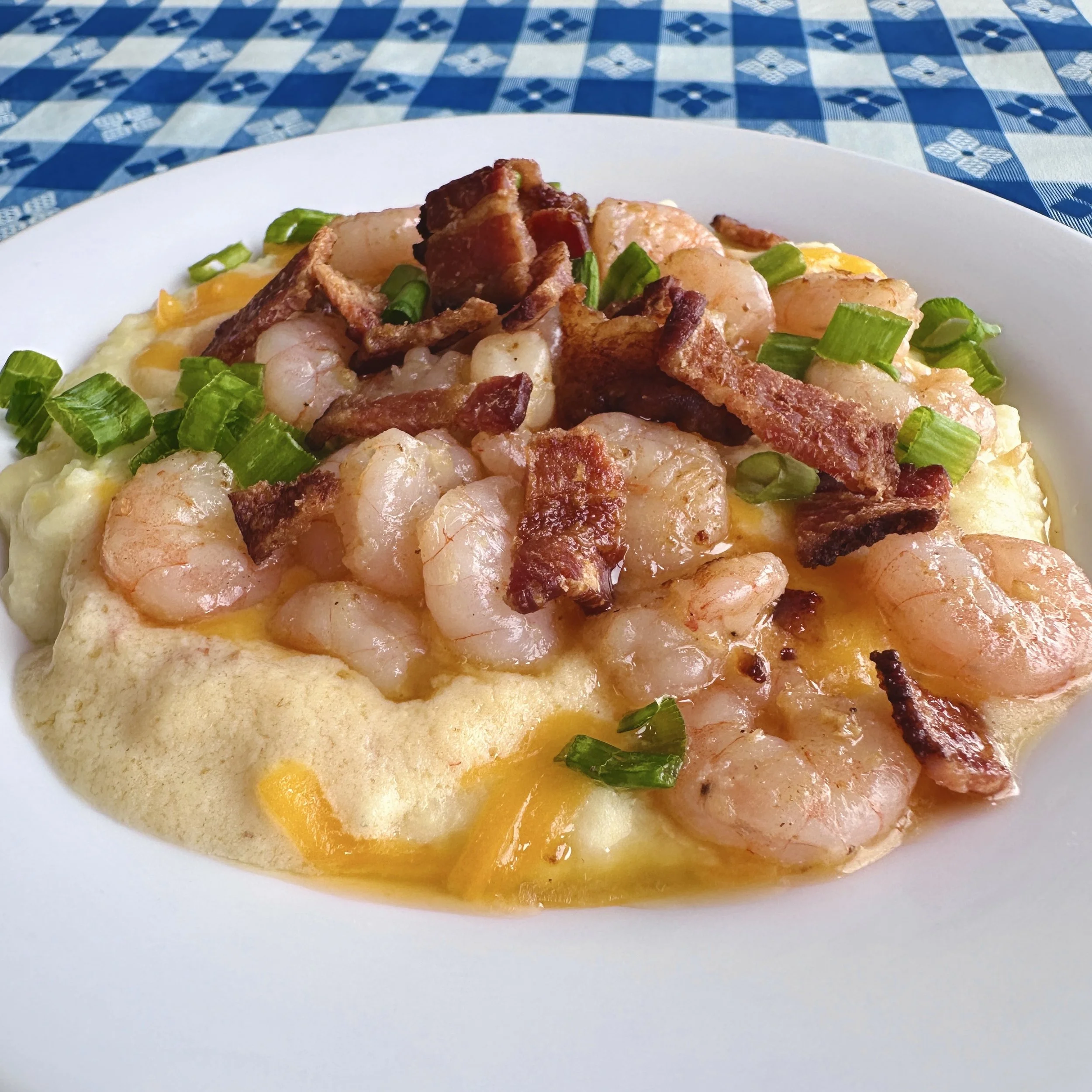 Shrimp and cheese grits topped with bacon and scallions