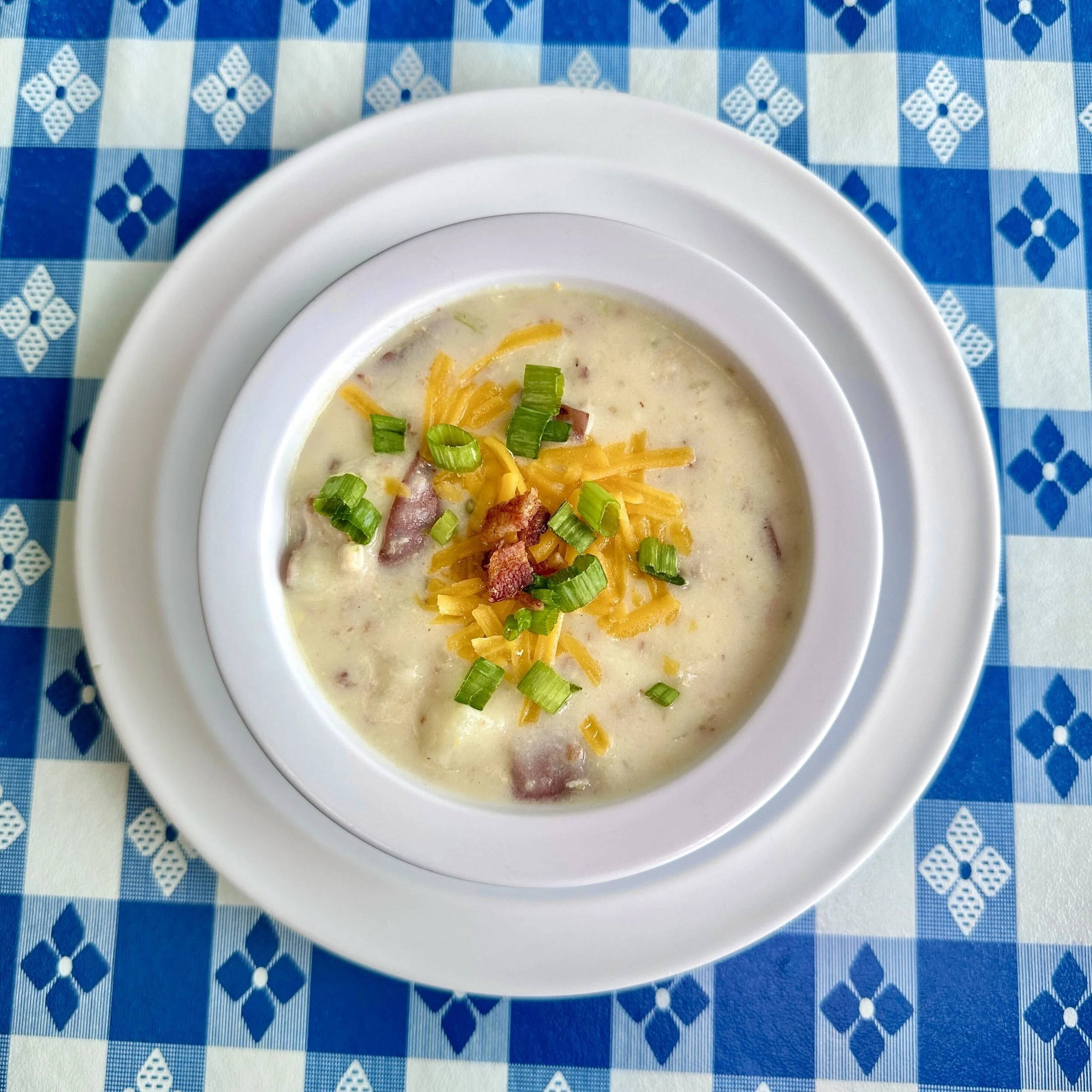Loaded potato soup topped with cheddar, bacon, and scallions