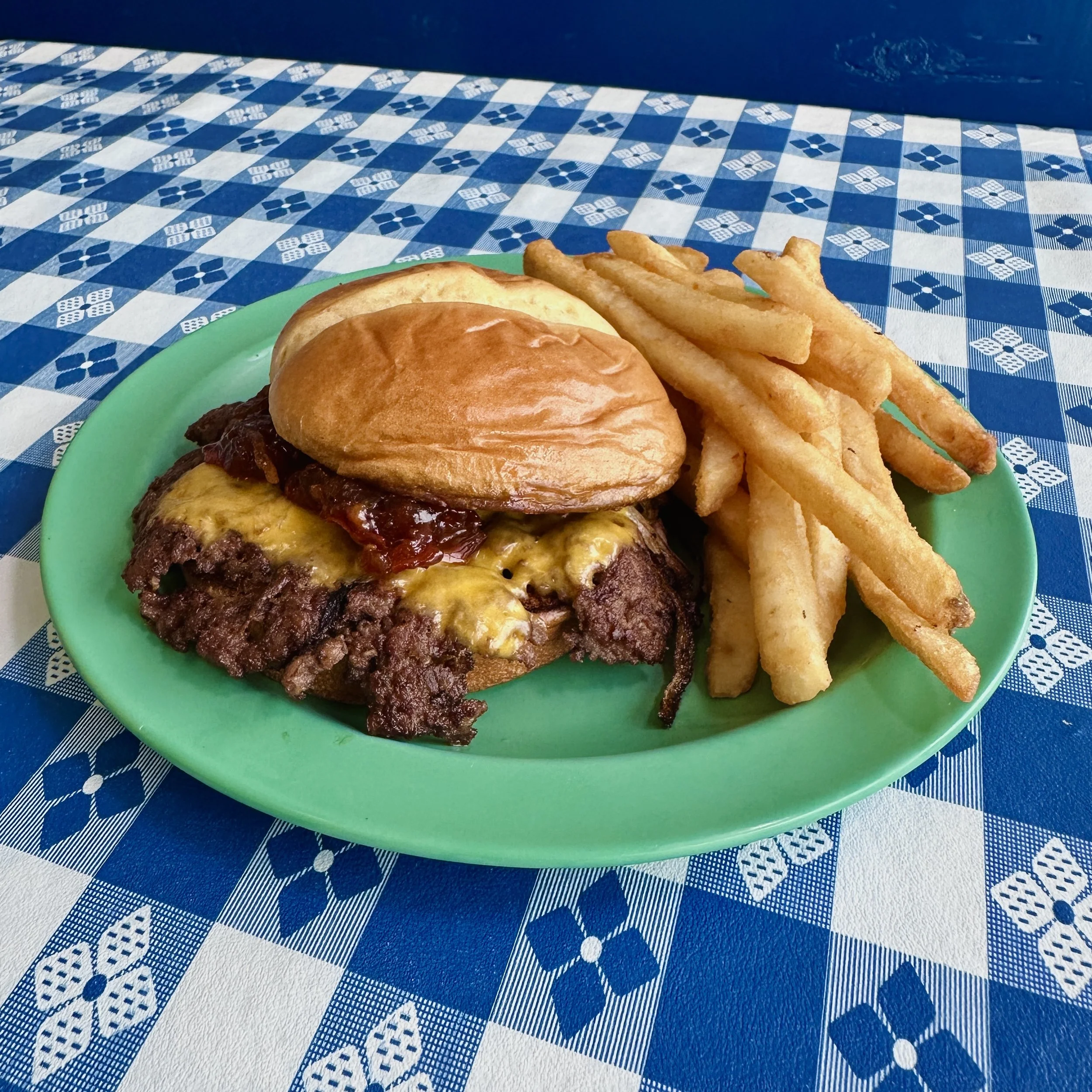 Smash burger with melted American cheese and a side of french fries