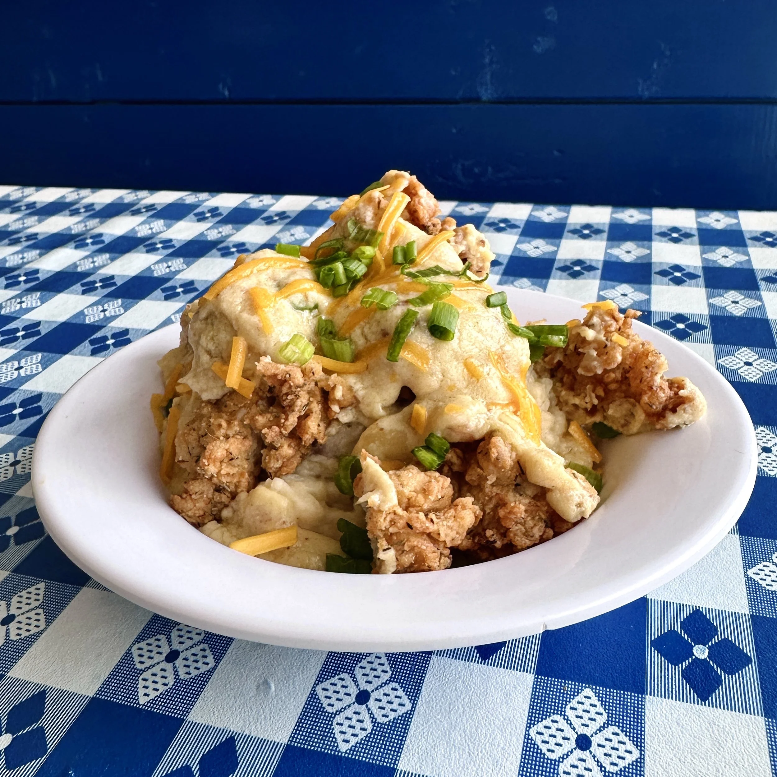 Chicken tender bowl with crispy tenders, cheese, and scallions