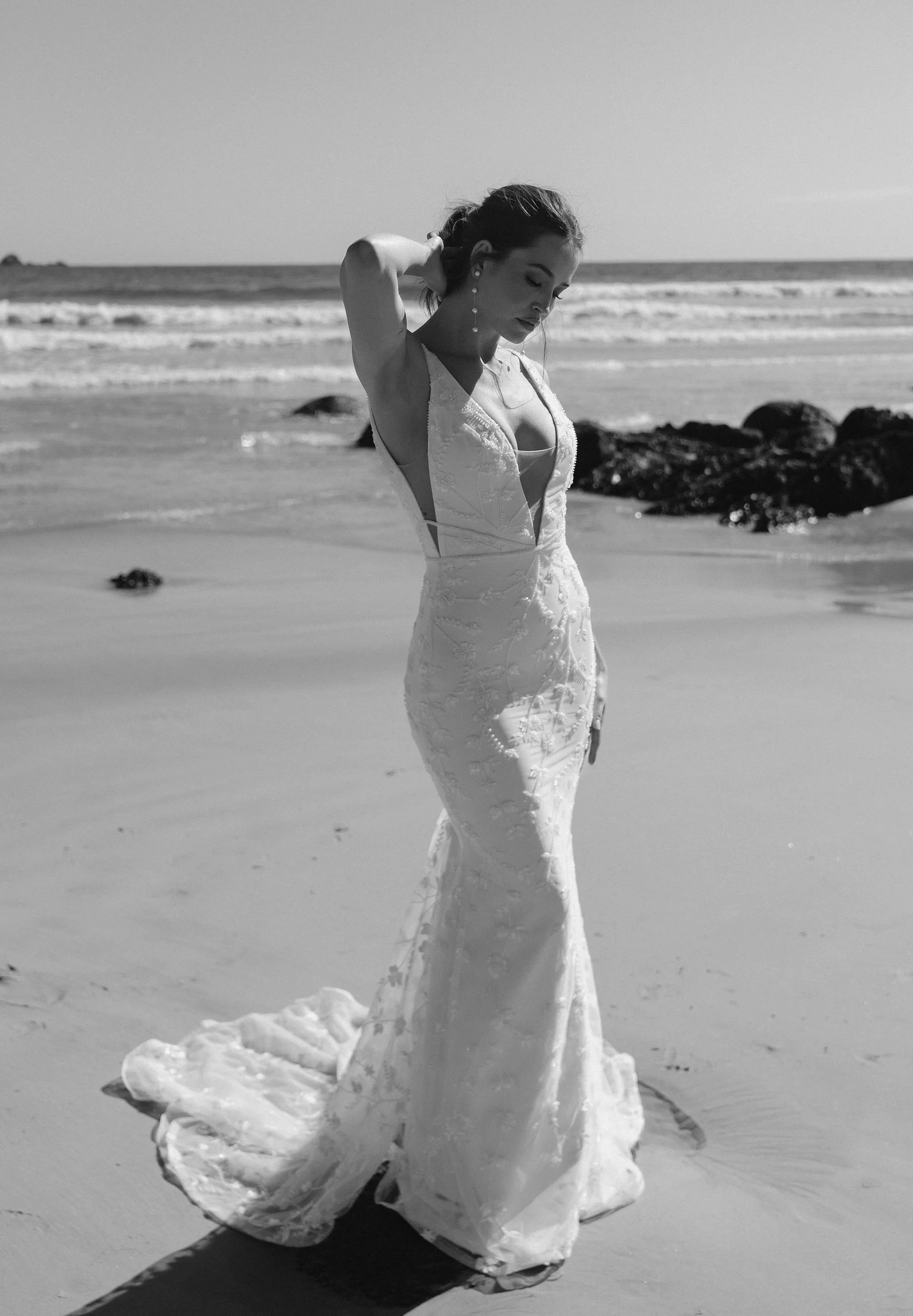 Form-fitted gown with a low plunge V neckline. Featuring custom floral lace with hand beaded pearls embellishments.