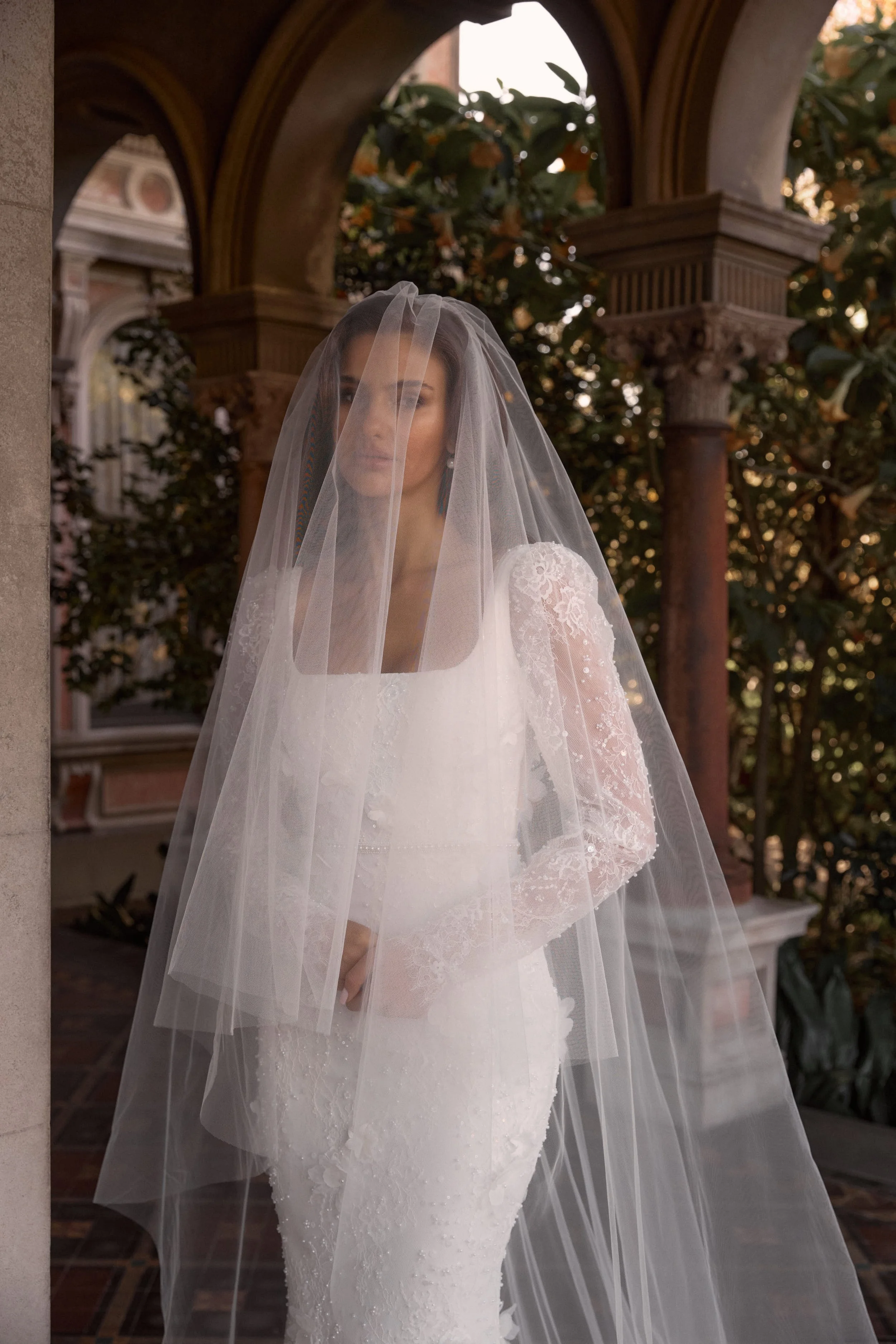 The James gown paired with a dramatic cathedral veil and blusher creates a breathtaking bridal look—featuring pearl-beaded lace, 3D florals, and a romantic square neckline.