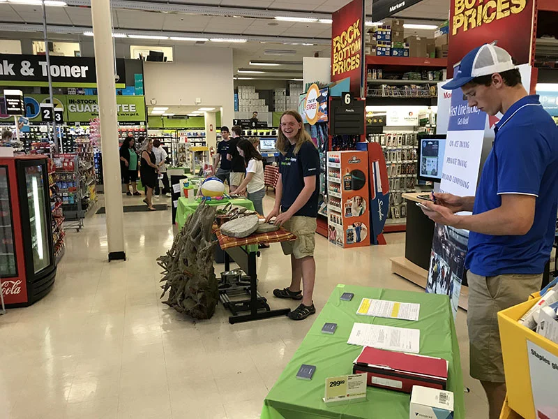 Young entrepreneur Gavin Brady (centre) arranges his display for his business, Midloch Farms, as part of a trade show at Staples in Cobourg. Brady is one of nine young people chosen for the Summer Company program run by the Business and Entrepreneurship Centre under the auspices of Northumberland County. Greg Powles (foreground) reviews his hand outs for this First Line Hockey school. Each person will receive a $3,000 micro grant, business training and mentorship as part of the program. Photo by Robert Washburn. 