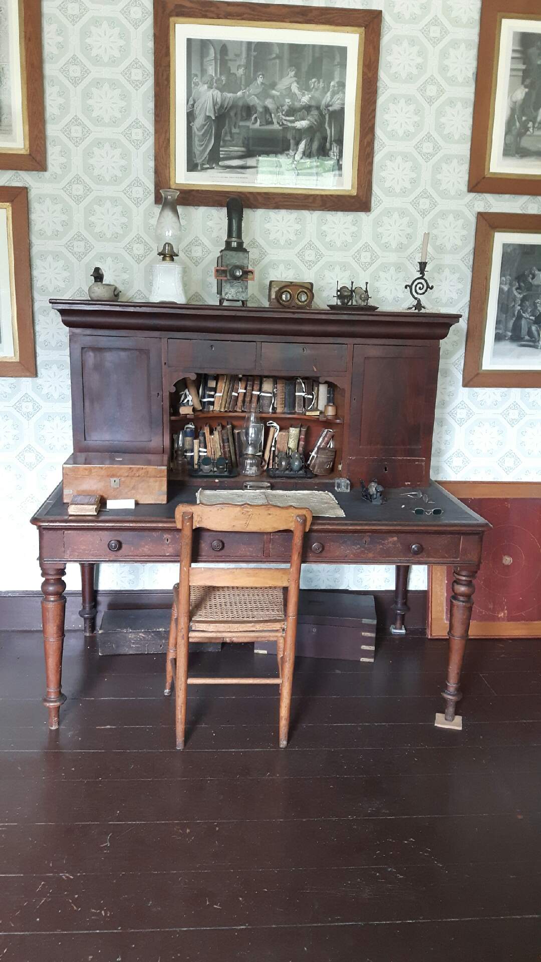  A desk in the study with prints of important Bible scenes on the walls 