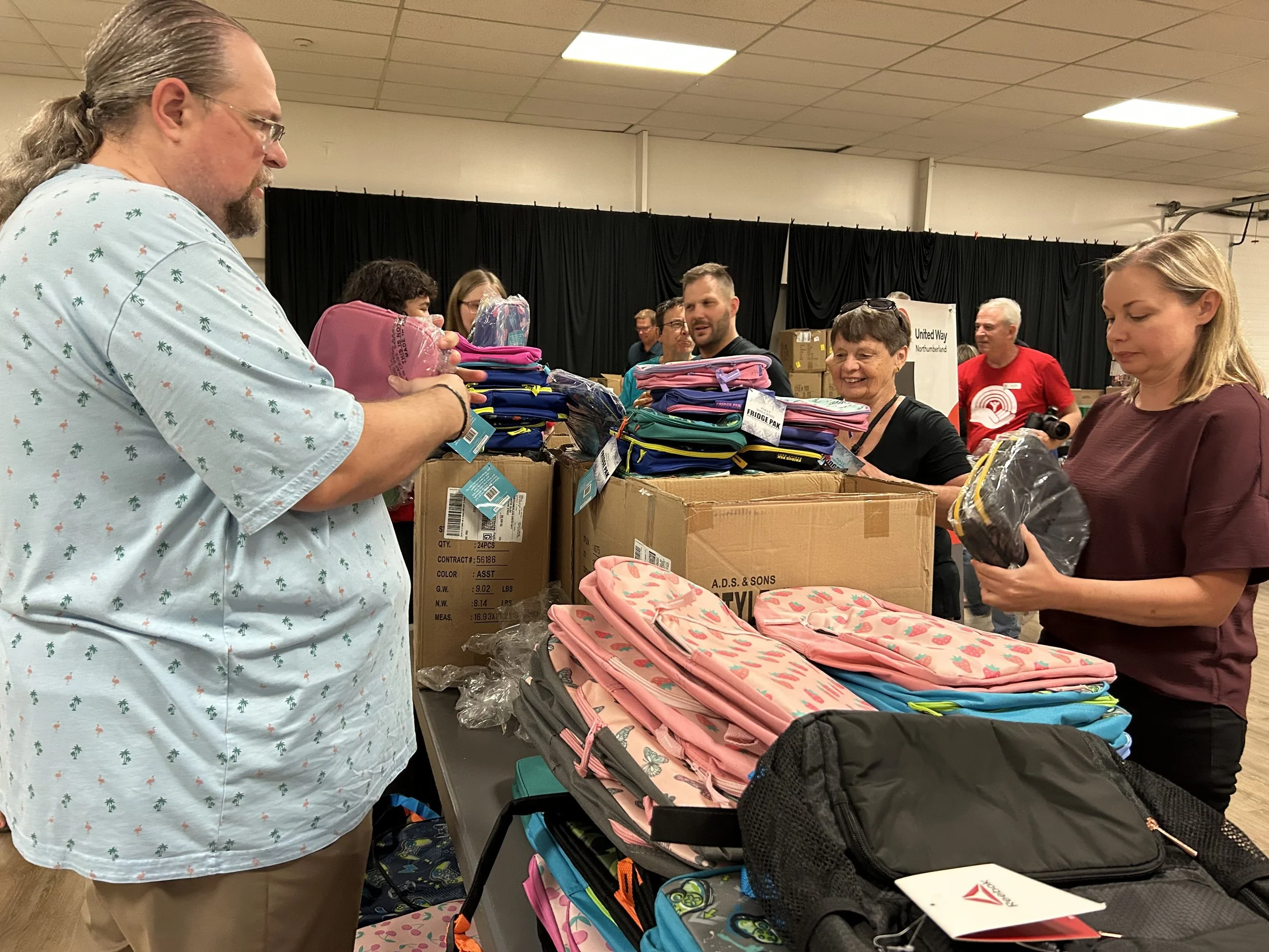 Volunteers prepare 850 backpacks for children in need