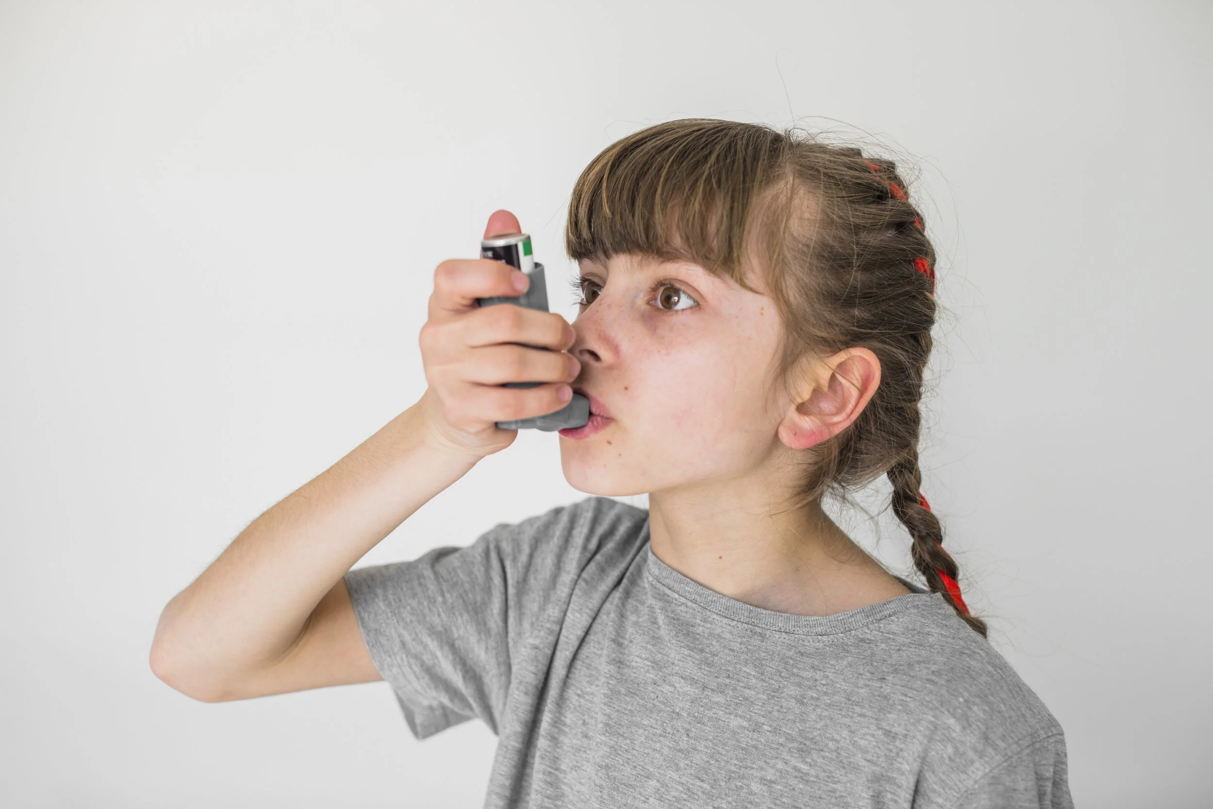Girl using asthma inhaler